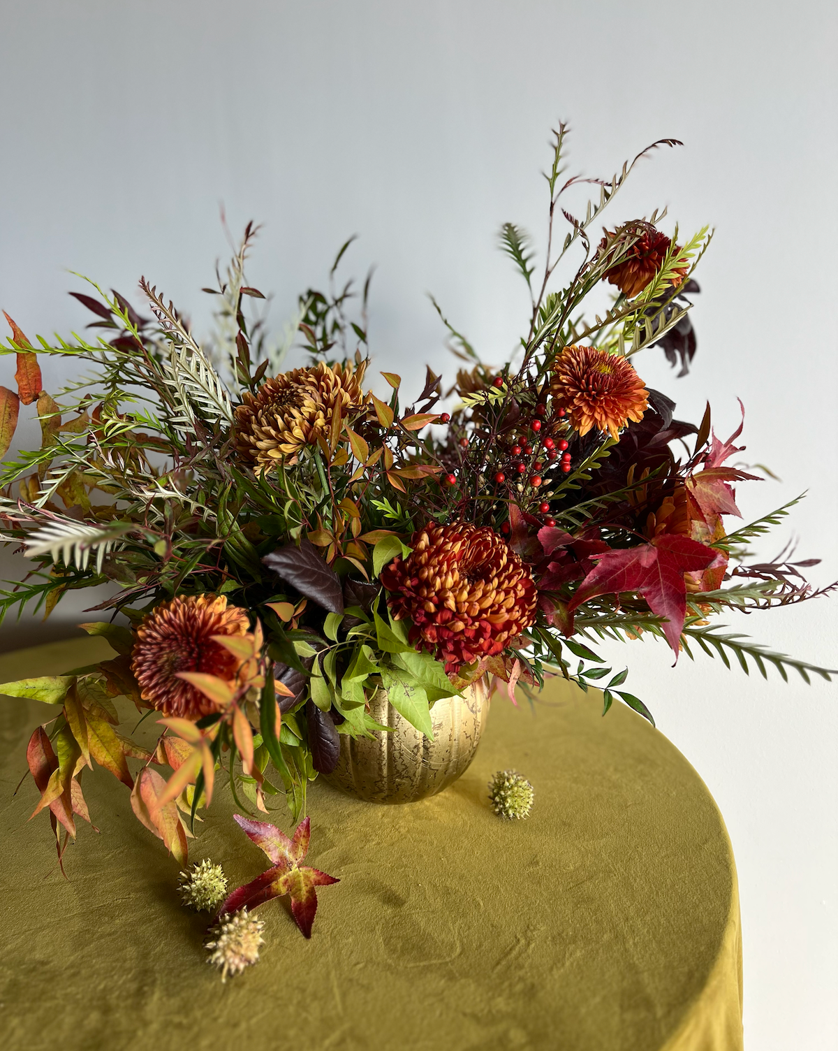 floral arrangement on a green velvet tablecloth with text that says done for you decor