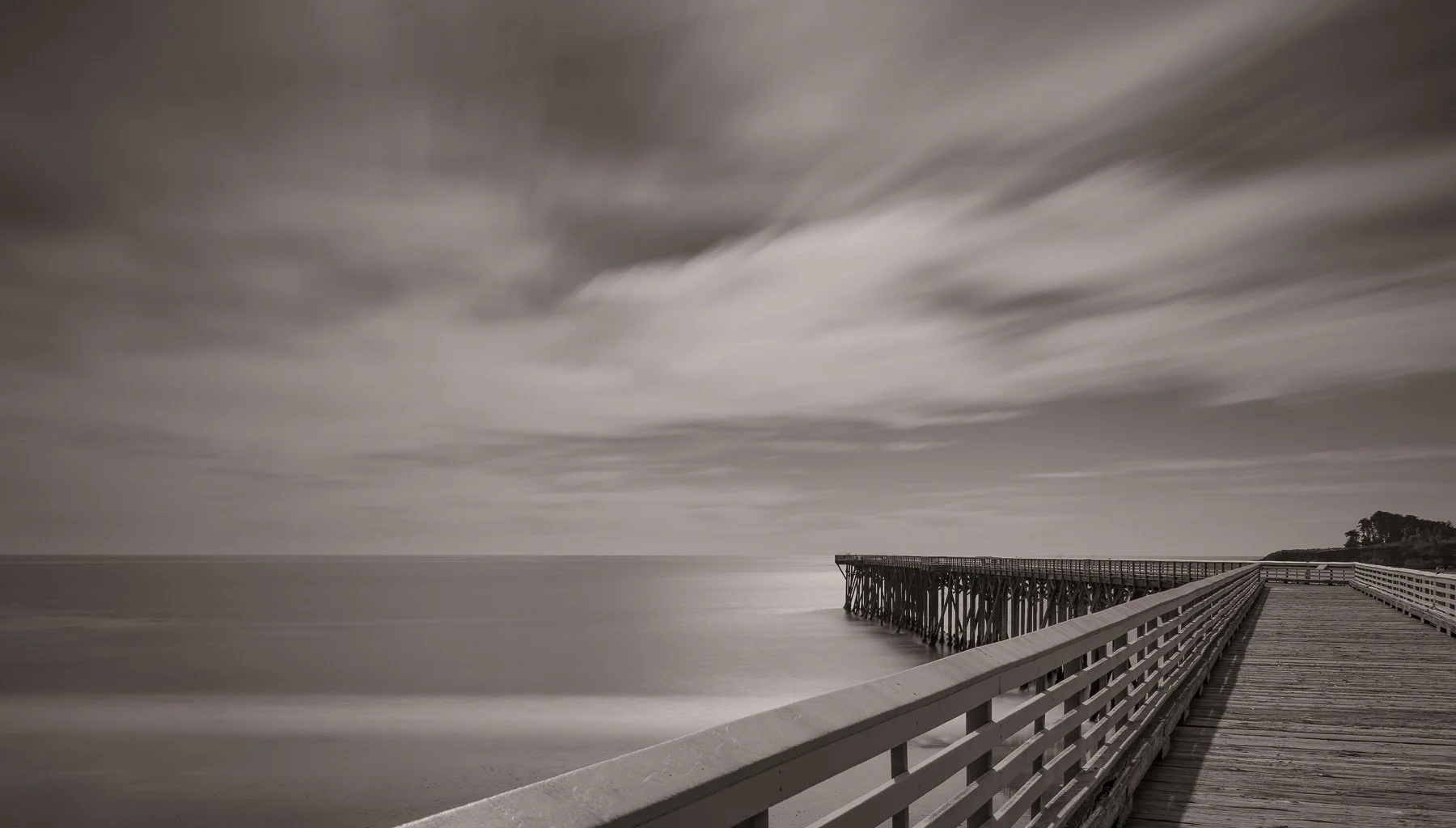 Long exposure of a pier jutting in ocean captured by Raj Sarda Photography