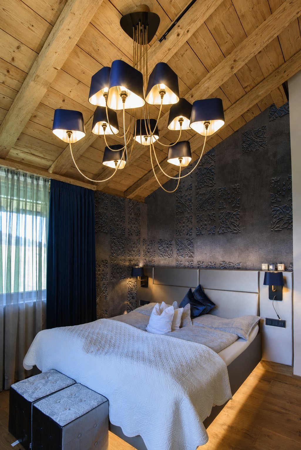 Schlafzimmer mit sichtbaren Dachbalken in Dunkelblau und Tapete von Wall and Deco