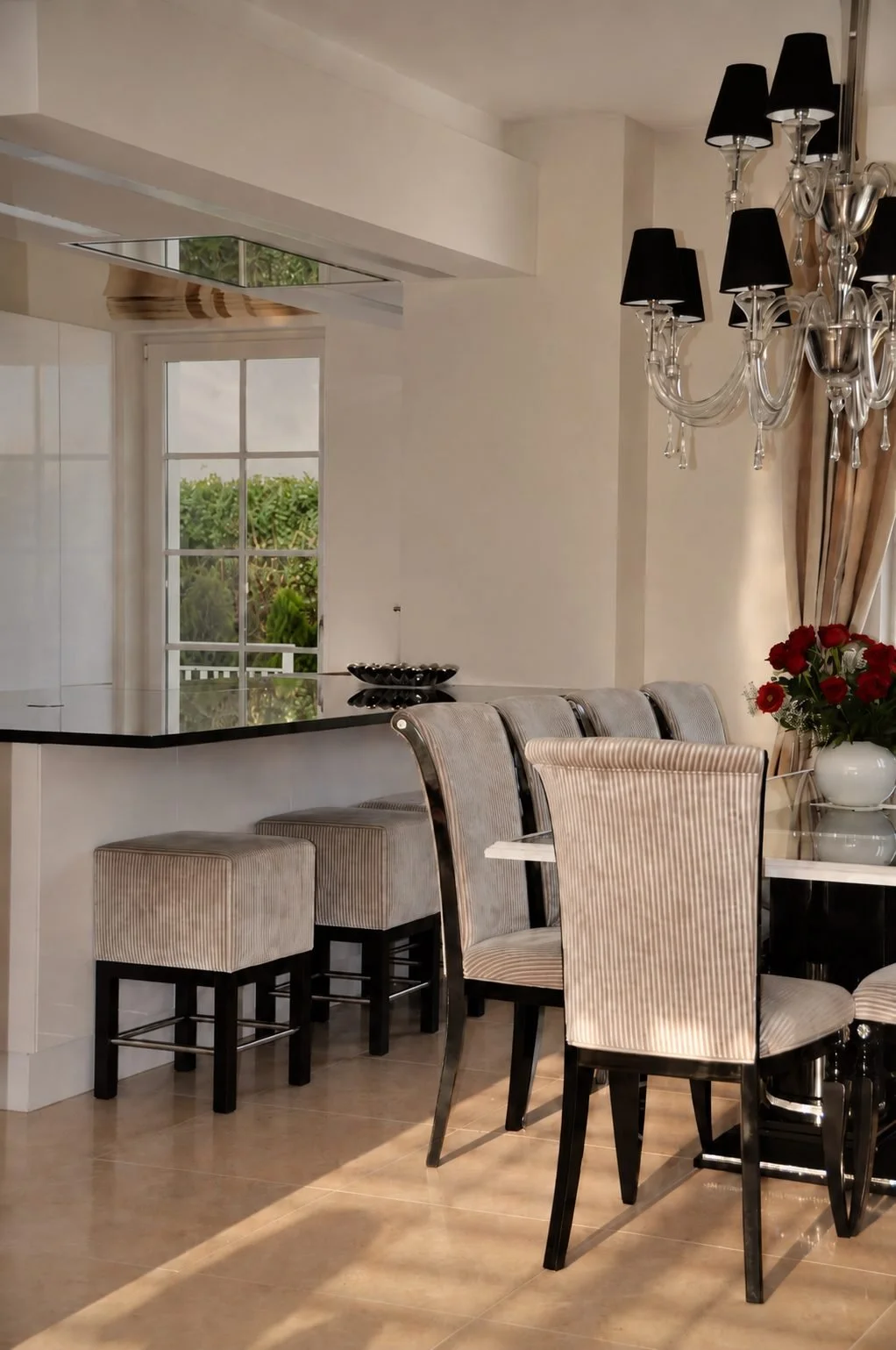Eleganter Essbereich mit gepolsterten Stühlen, Glasluster und angrenzender offener Küche in einem hochwertigen Interior Design.