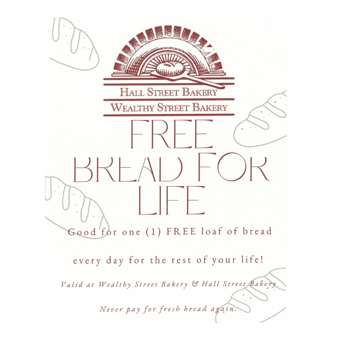 Promotion for free bread at Hall Street Bakery and Wealthy Street Bakery with a drawing of a loaf of bread and some bread slices around the text, offering one free loaf per day.