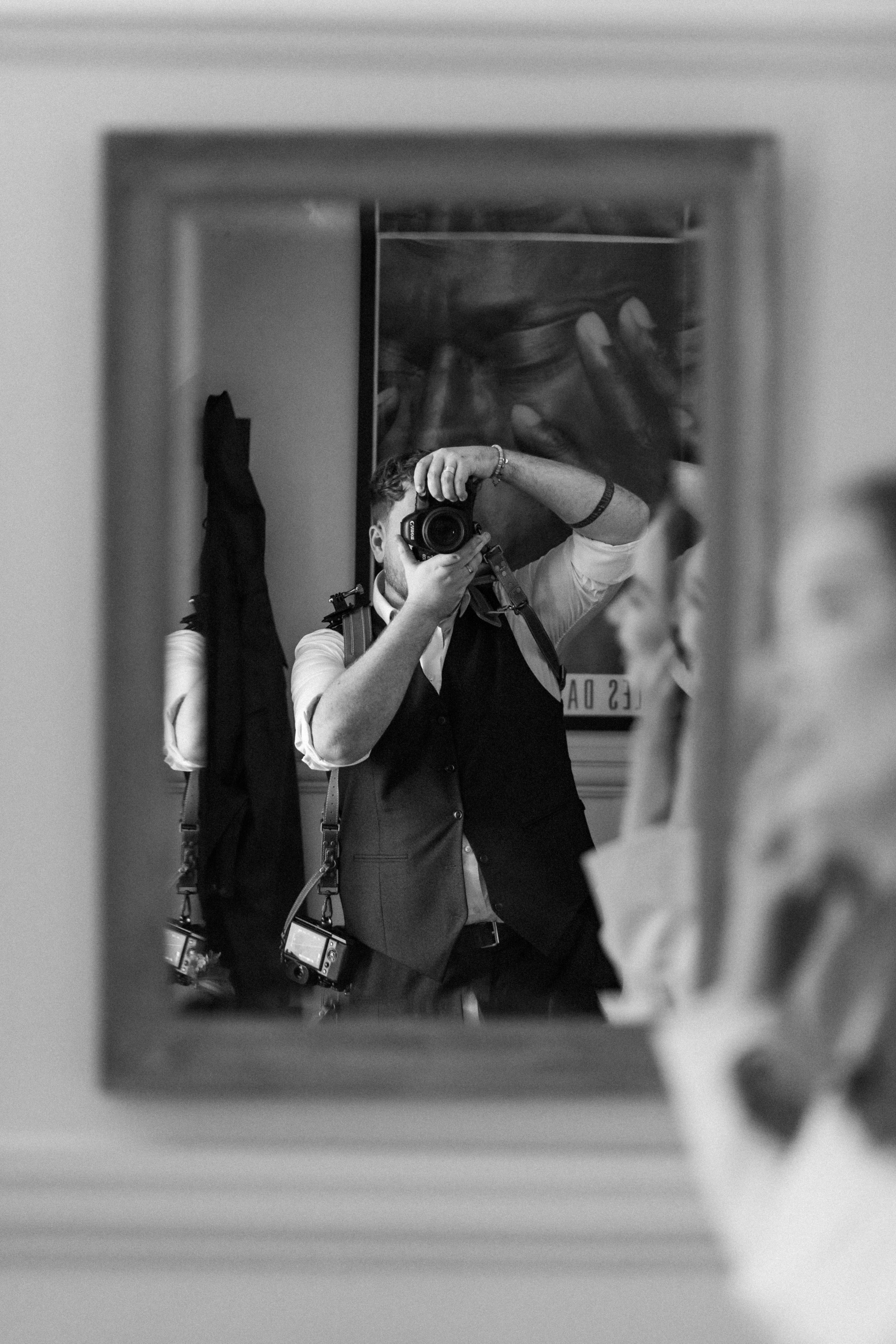 Black and white mirror reflection of a photographer taking a photo.