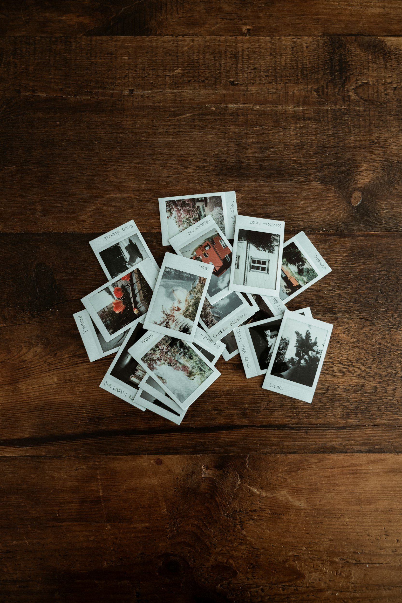 Pile of Polaroid photos on a wooden table