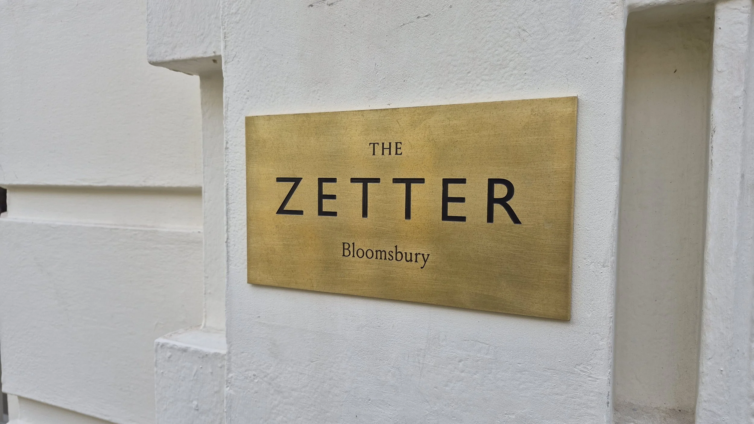 A gold-colored plaque mounted on a white wall reads 'The Zetter Bloomsbury'.