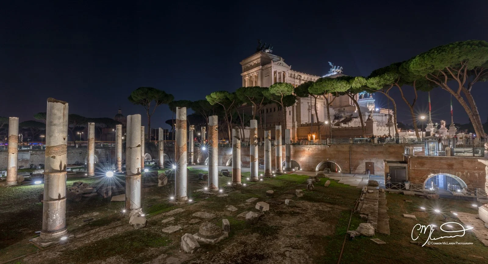 Roman Forum, Rome & the vatican. Night view of ancient ruins with columns and the Altare della Patria monument in Rome illuminated under the night sky.