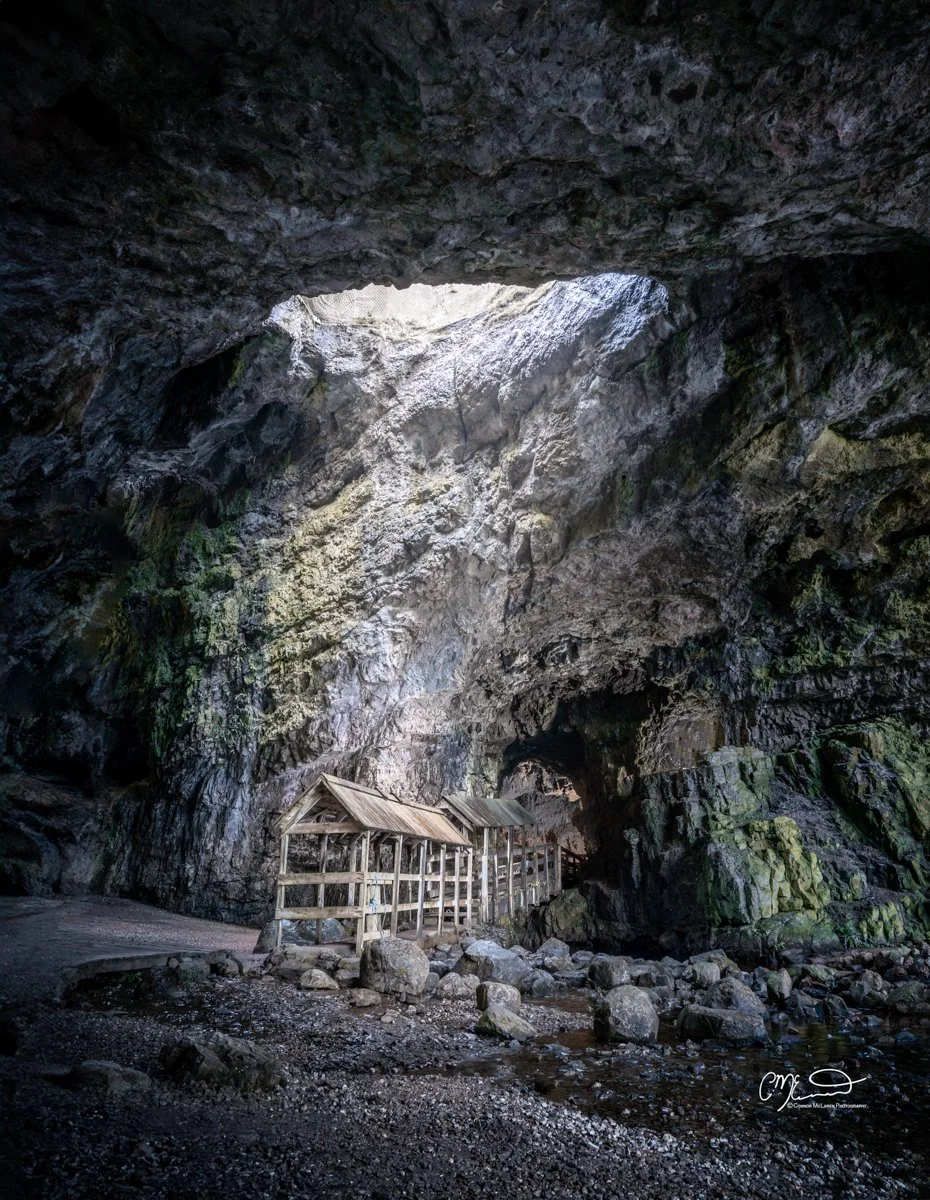 Scotland, north coast 500, NC500, Smoo Cave Durness. Inside a large rocky cave with a small wooden shelter and uneven ground with rocks and pebbles.