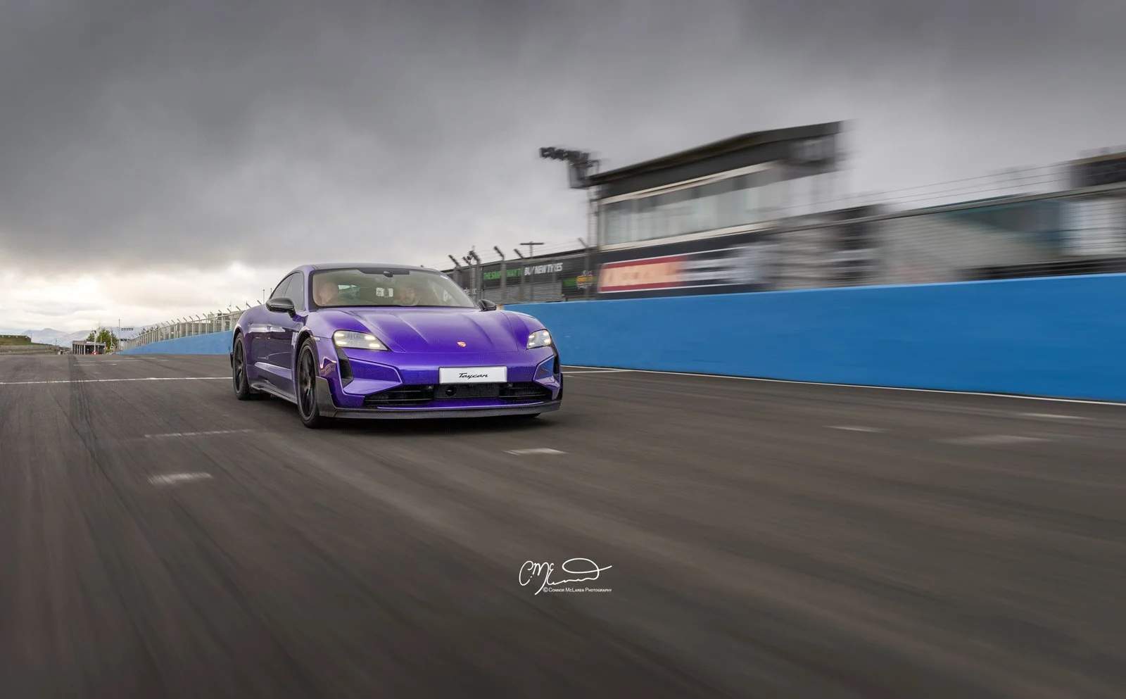 Porsche Taycan Turbo GT in purple racing at Knockhill. A purple sports car racing on a track under a cloudy sky, with motion blur on the background.