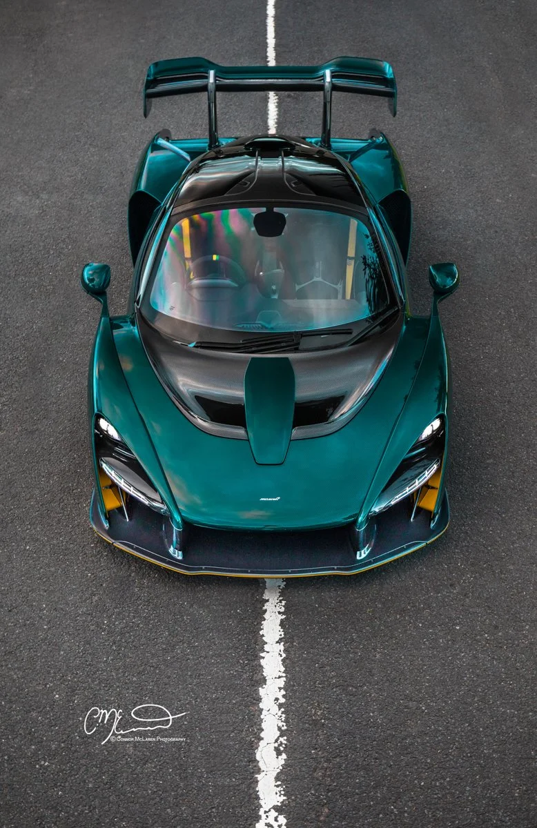 MSO McLaren Senna, full Carbon Green. Top view of a teal-colored sports car with a large rear wing, positioned on a parking lot line.
