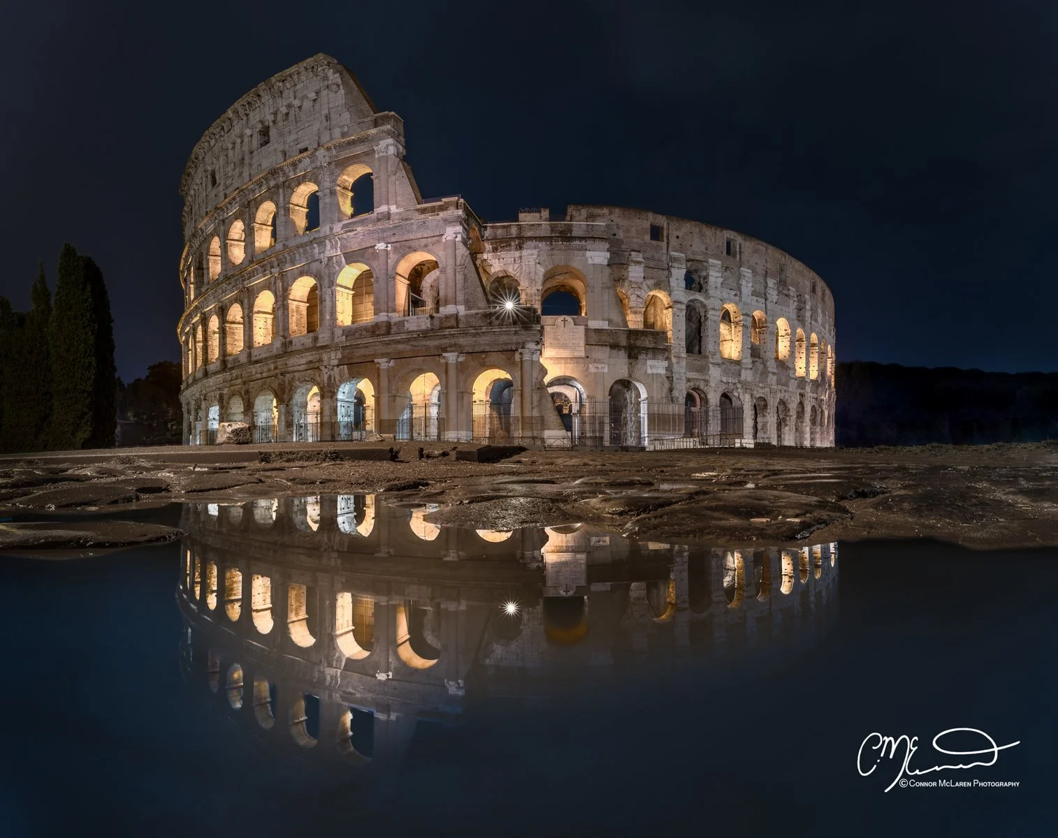 Roman Forum and colosseum, Rome & the vatican. Nighttime photograph of the illuminated Roman Colosseum reflected in a water puddle.