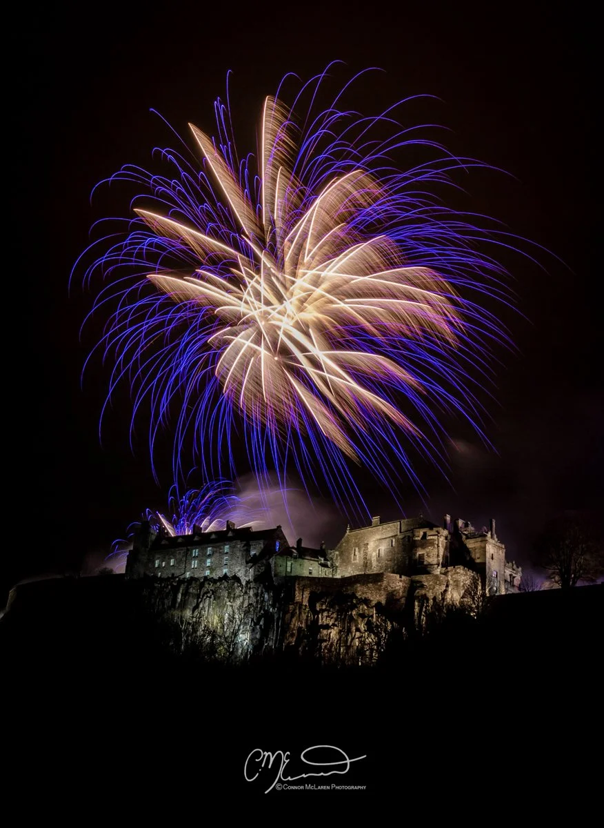 Scottish Lowlands, Scotland, stirling castle. Fireworks exploding above a castle on a dark night sky.