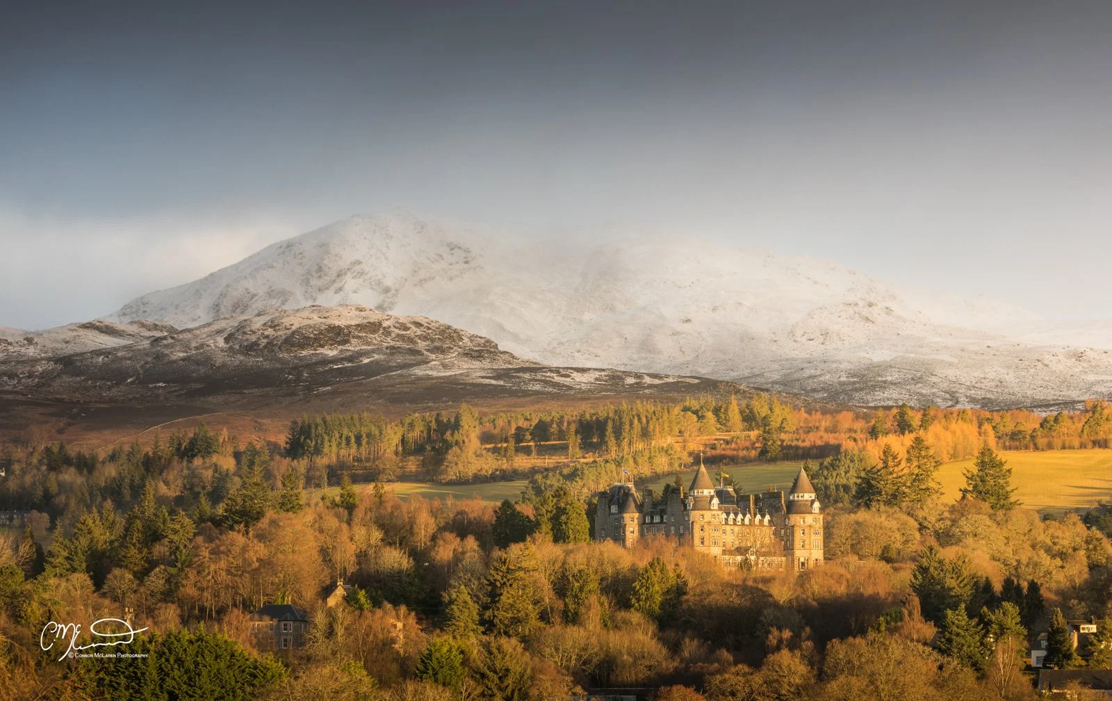 Scottish Central Highlands, Scotland, Perthshire atholl palace. Castle on a hill with a forested landscape and snow-capped mountains in the background