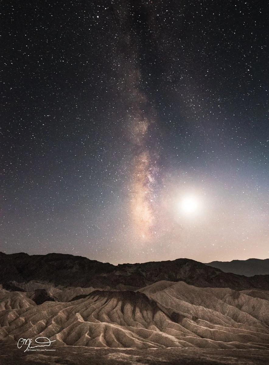 Death Valley national Park USA. Nighttime desert landscape with rugged hills under a star-filled sky and the Milky Way galaxy visible.