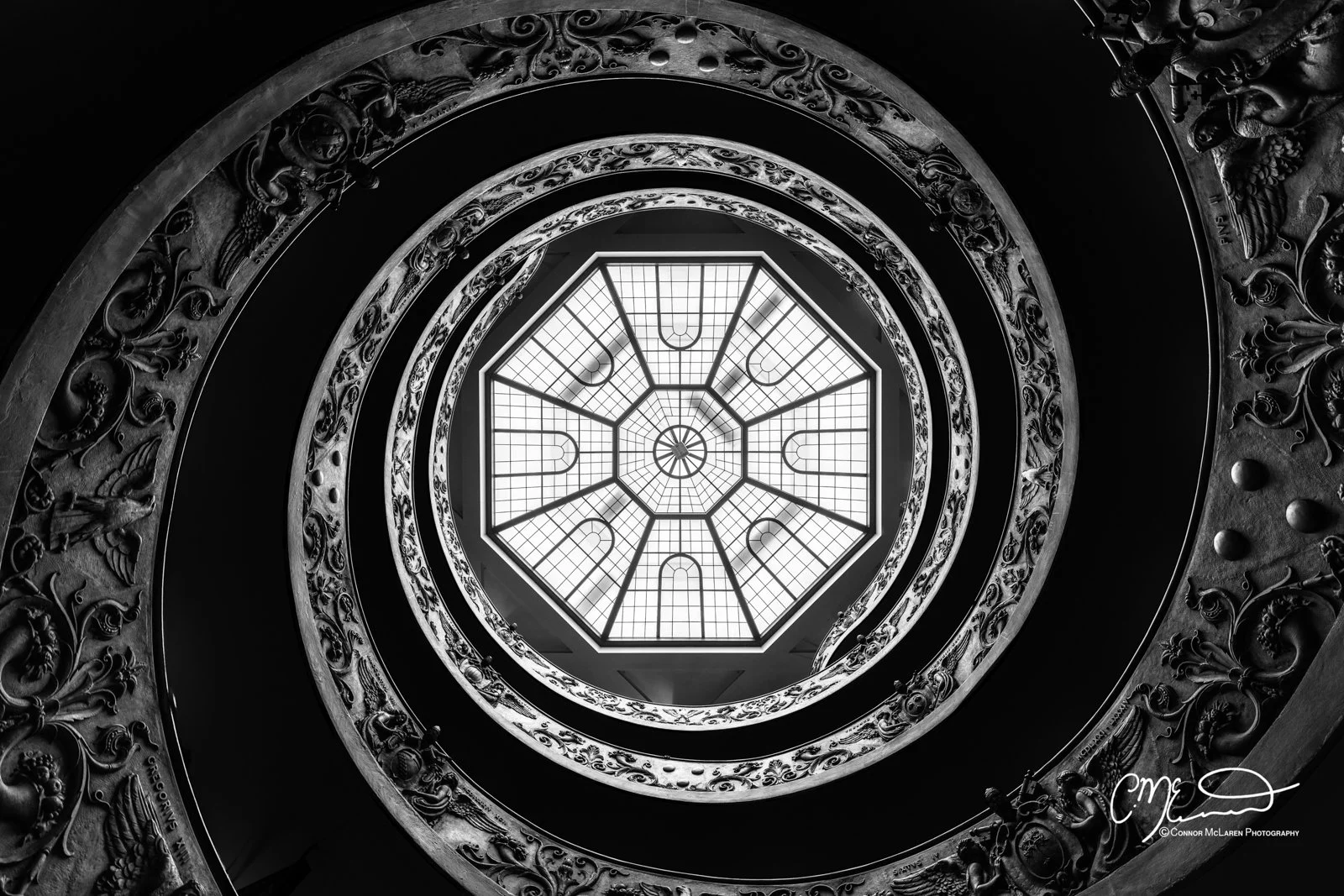 Italy, Rome, vatican. A spiral staircase looking up at a glass ceiling with geometric patterns.