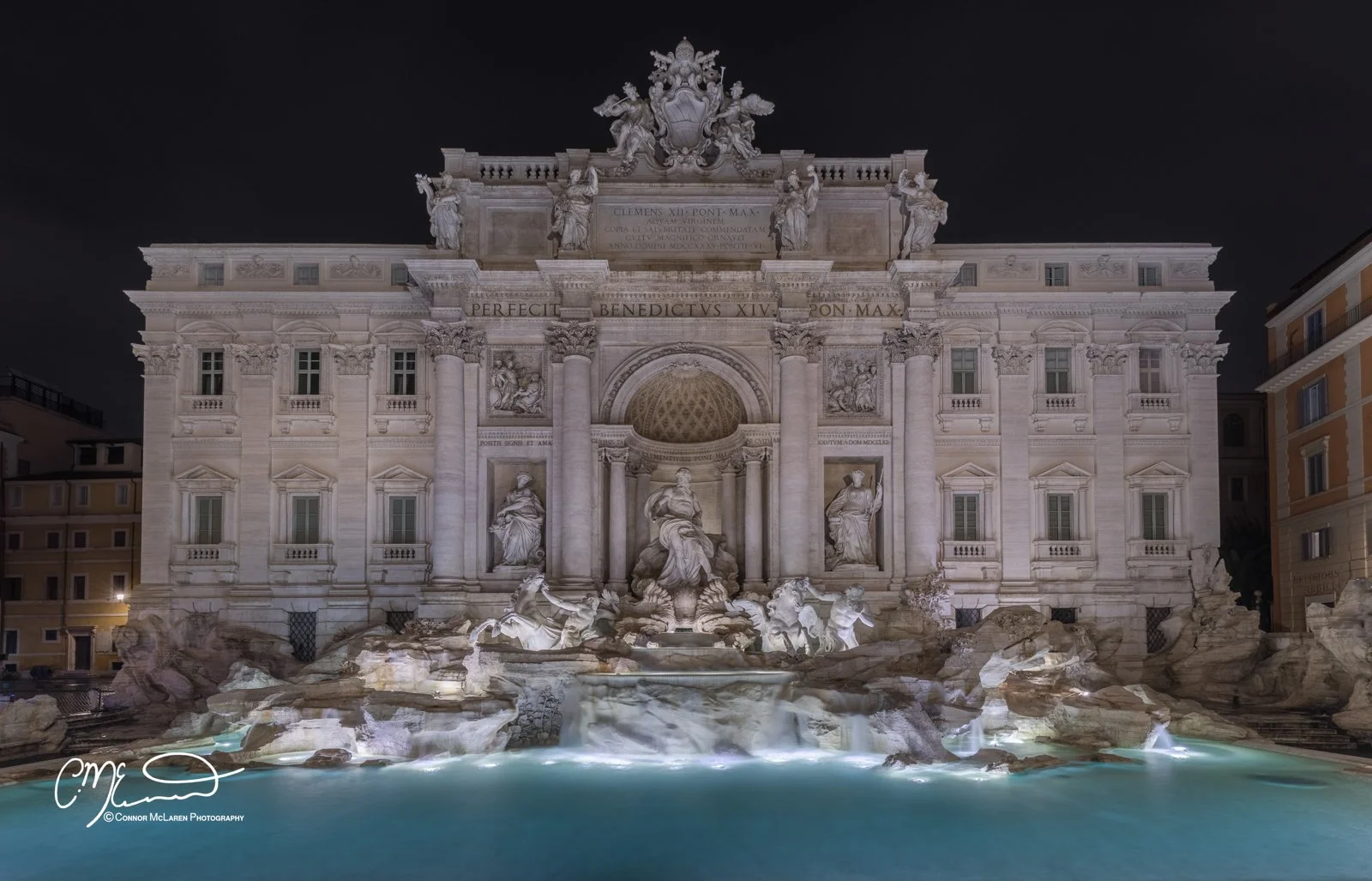 Trevi Fountain, Roman Forum and colosseum, Rome & the vatican. Nighttime view of the Trevi Fountain in Rome, Italy, illuminated with water flowing over the sculptures and rocky base.