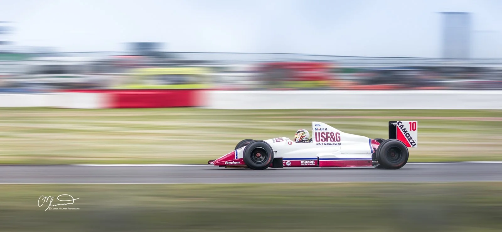 Classic Formula one car racing at Silverstone. A race car on a track with a blurred background showing movement and speed.