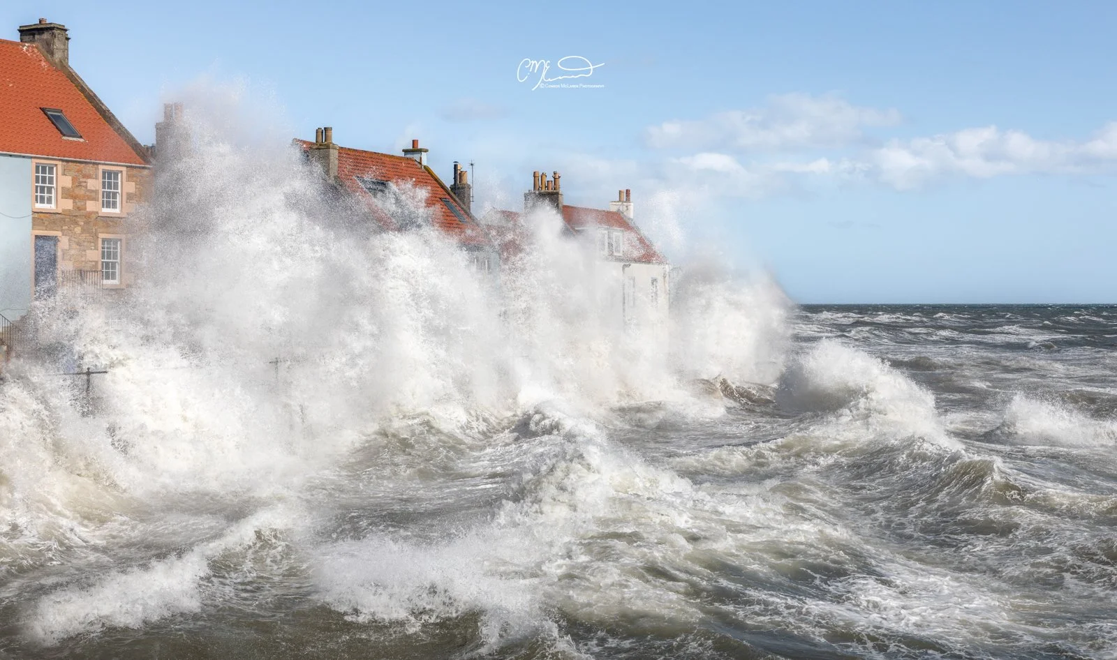 Scottish Lowlands, Scotland, east neuk of fife. Waves crashing against houses along the shoreline during stormy weather.