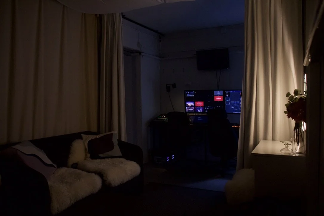 En professionell filmkameror med en liten monitor, placerad framför en grön bakgrund.