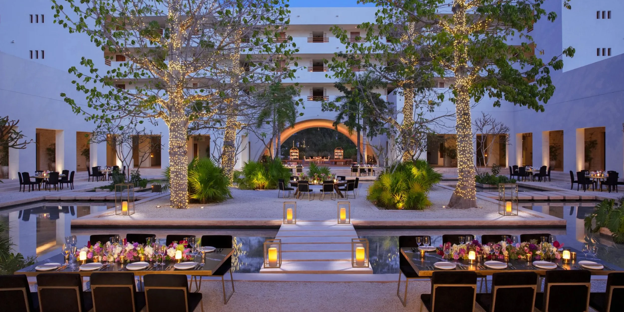 Bold tropical floral garden ceremony setup at Secrets Akumal in lavendar, Riviera Maya destination wedding venue