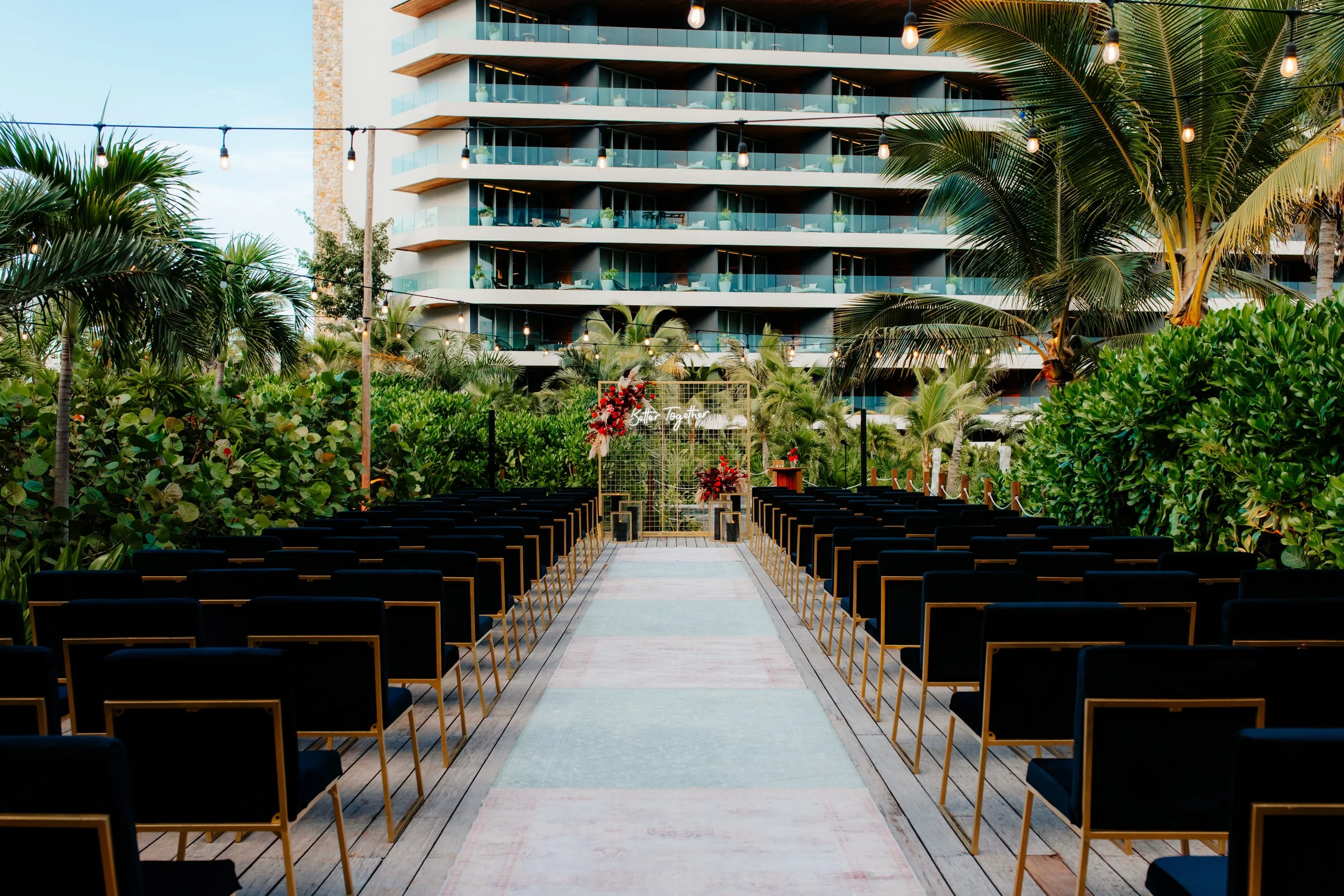 Modern jungle garden wedding venue at Secrets Moxche with dark wood ceremony arch surrounded by dense tropical greenery