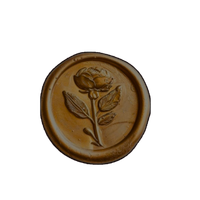 A gold wax seal with a rose on it.