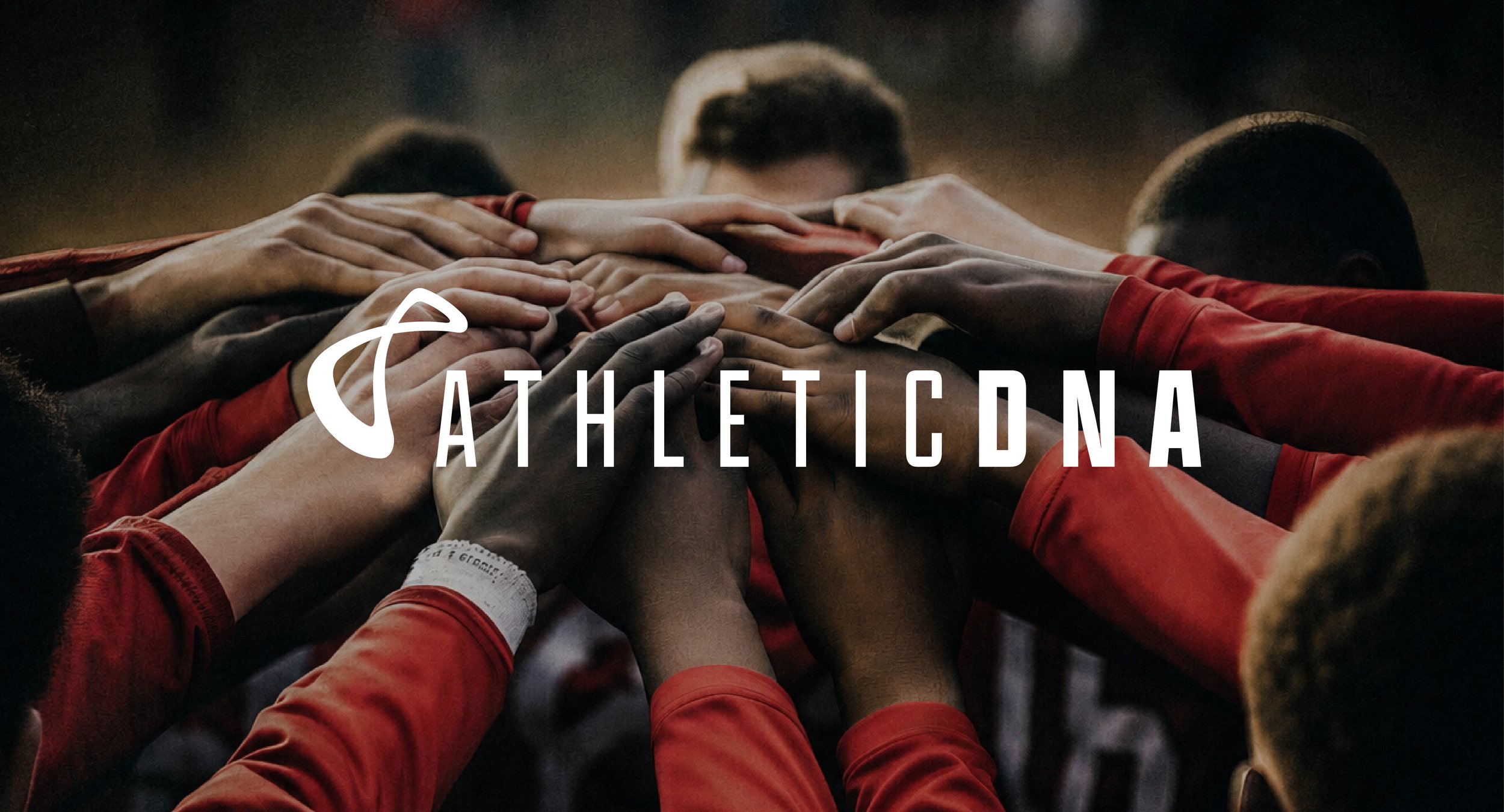 Multiple athletes in red uniforms placing their hands together in a team huddle, with the word 'ATHLETICDNA' overlayed.