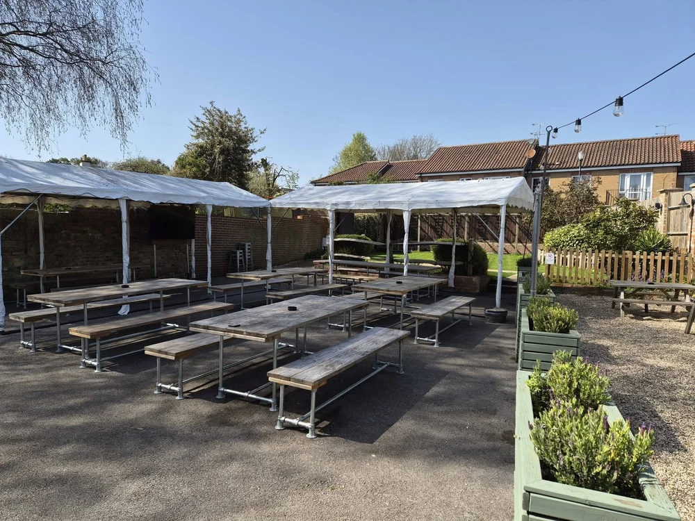 Picnic tables and covered seating in the Kings Arms beer garden