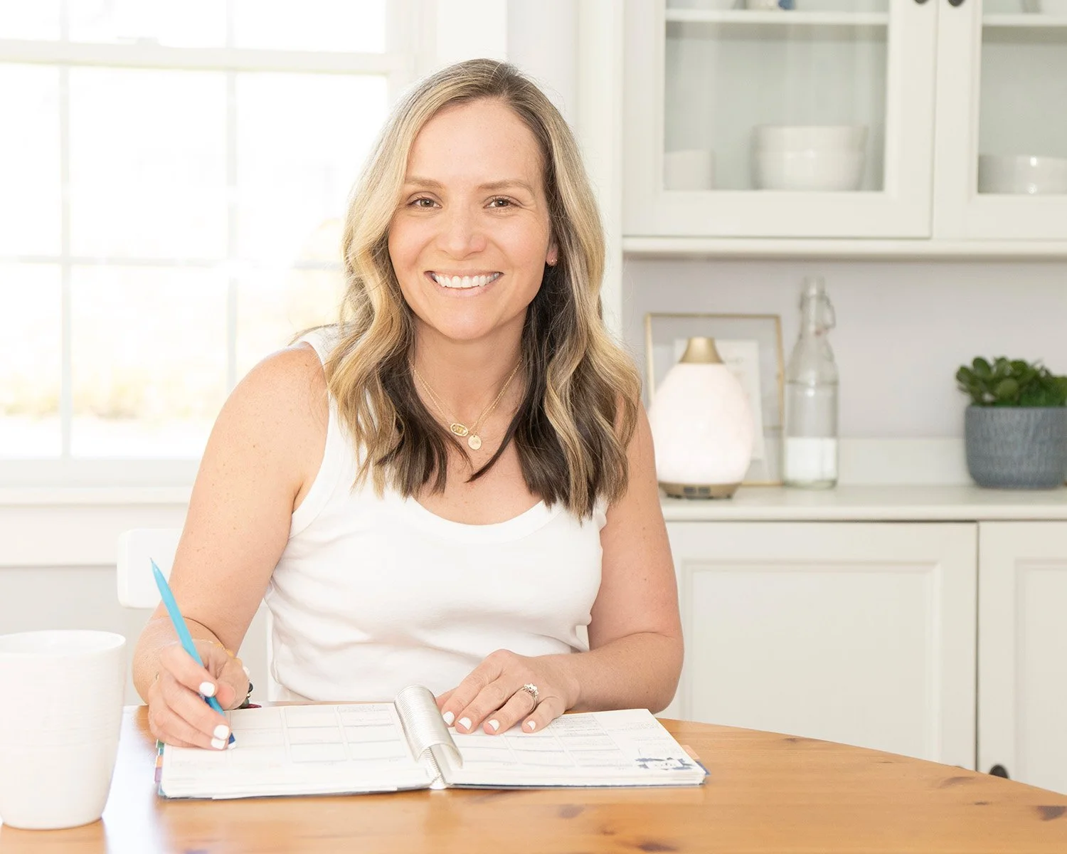 Sarah, sitting at her kitchen table with a planner