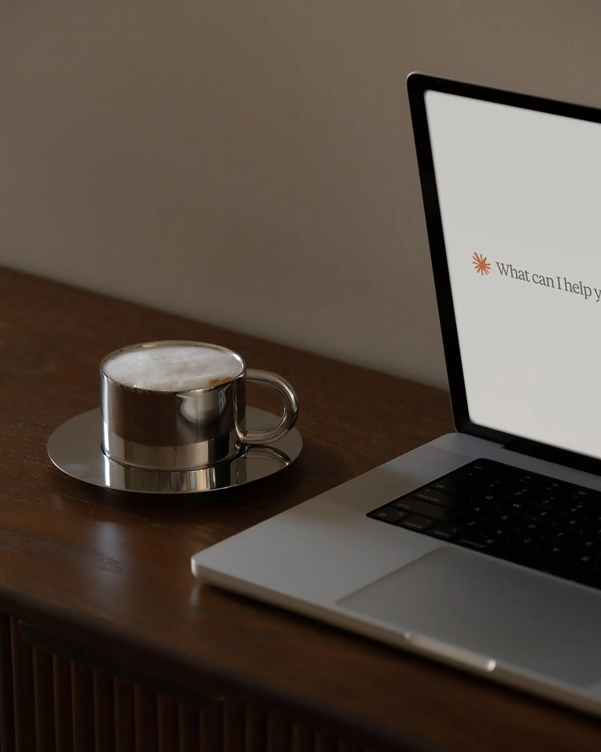 Laptop on minimal desk showing the Claude landing page