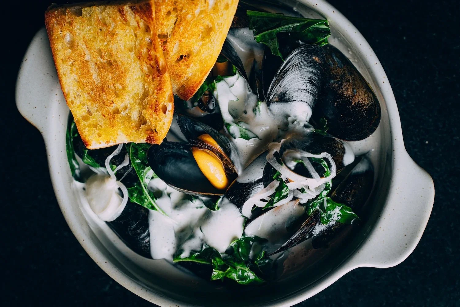 A bowl of mussels with White Wine, Blue Cheese, Spigarello