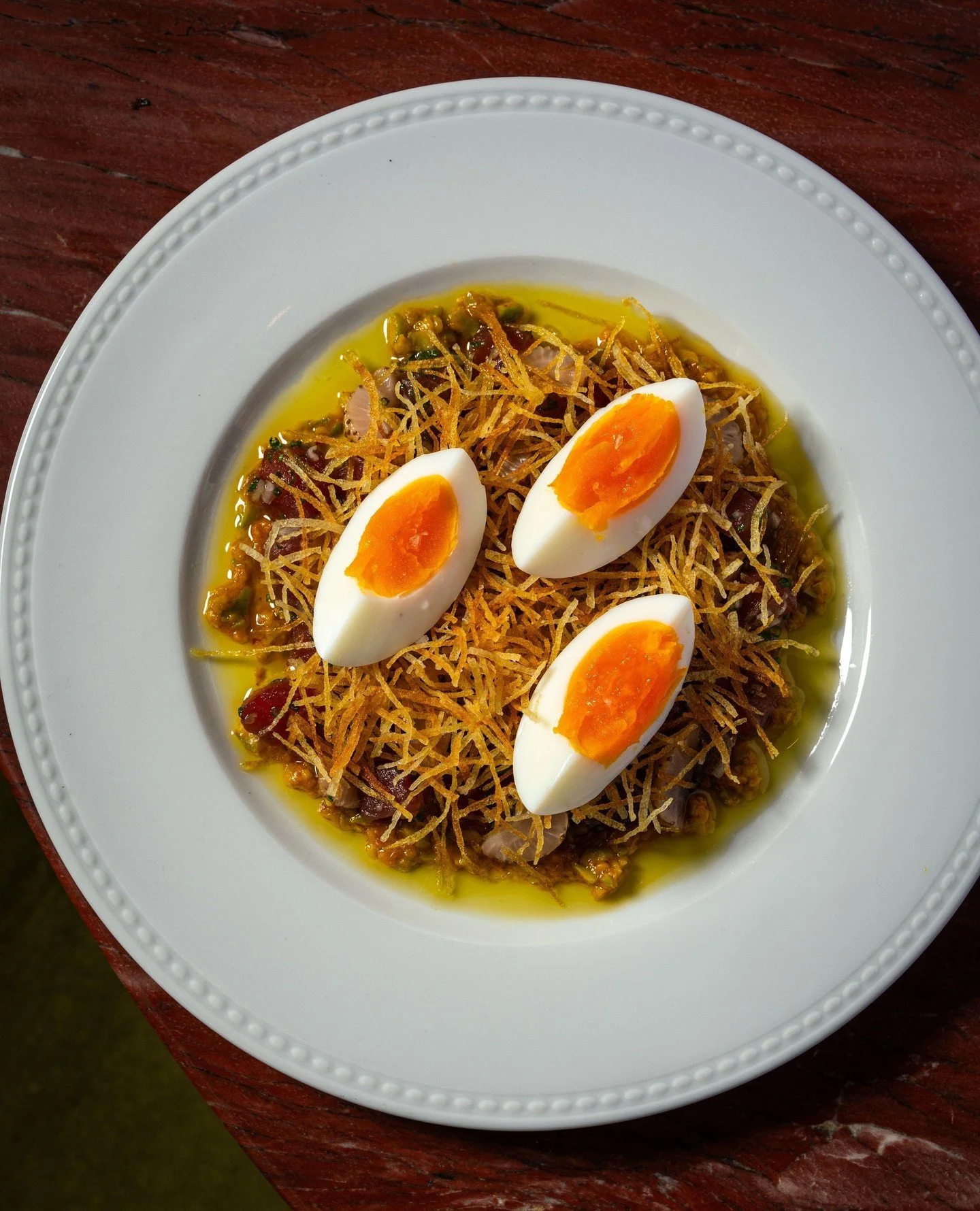 Our new crudo takes its cues from a classic Tuna Ni&ccedil;oise. Bluefin tuna, olive tapenade, egg yolk, crispy shoestring potatoes, and green strawberries.