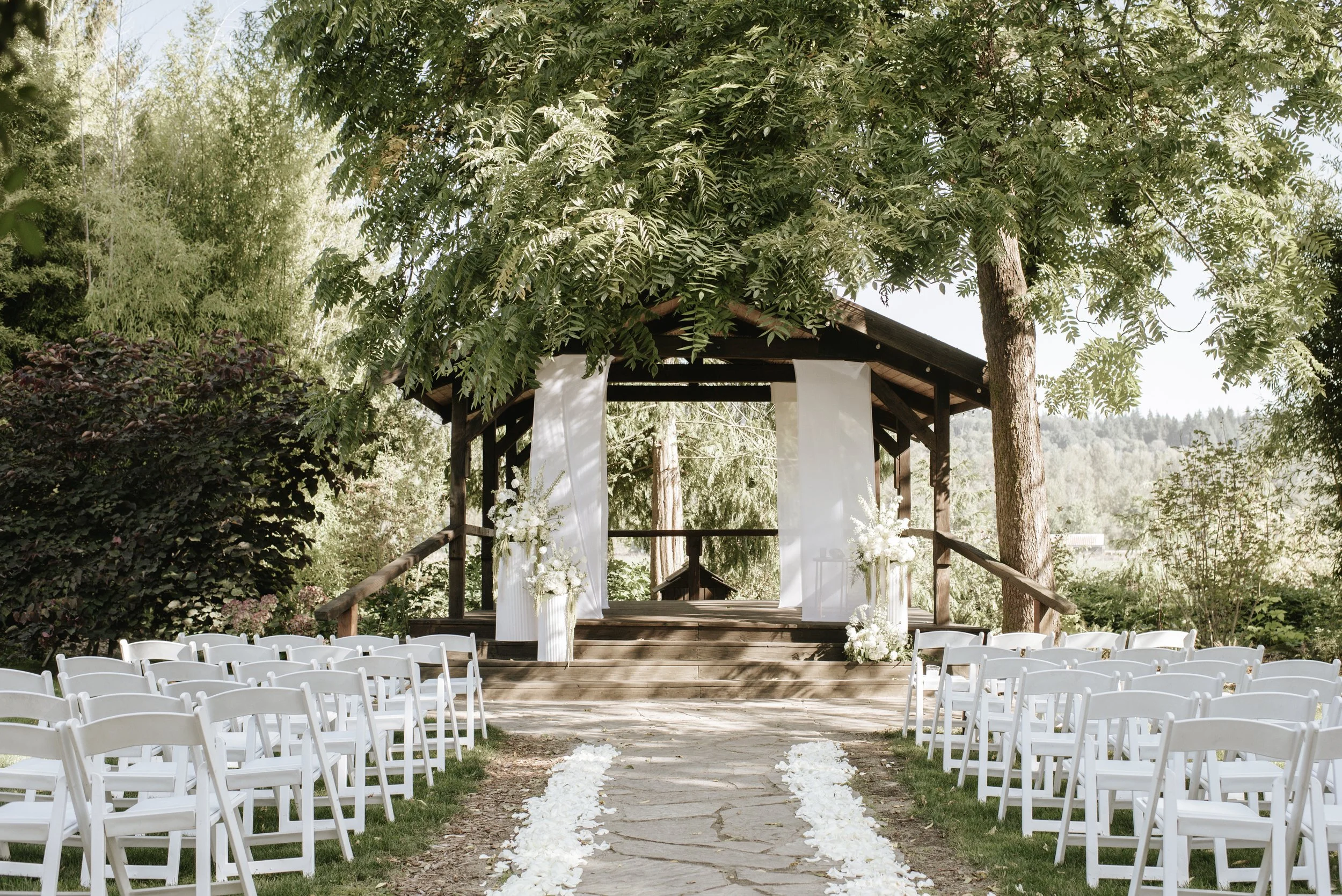 wedding ceremony garden with gazebo and wood benches