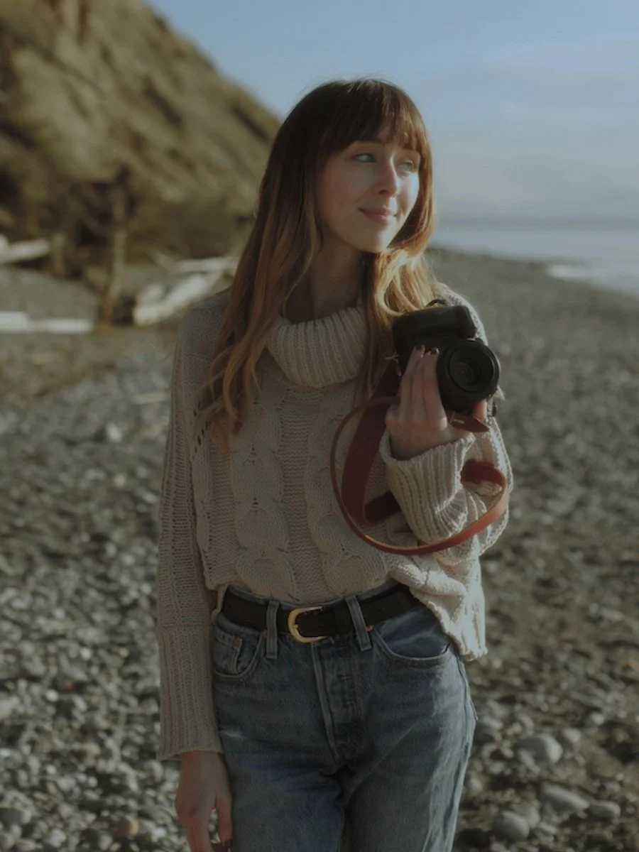 Travel elopement videographer with her camera on the washington coast