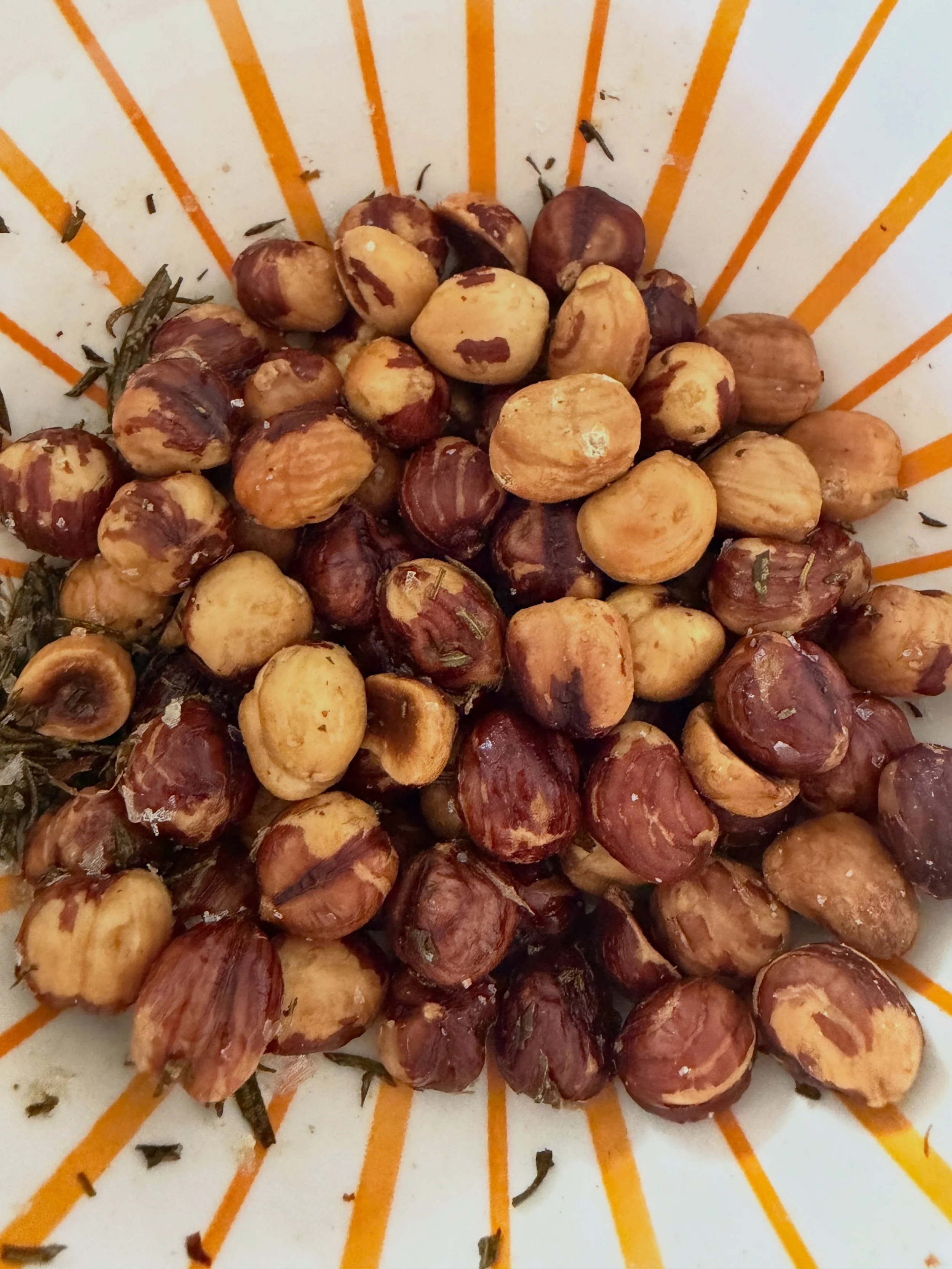Bar snacks in a jiffy! These rosemary roasted hazelnuts are my salty treat of the week and so easy to make. Oven at 400, hazelnuts on a sheet pan with sides, olive oil, chopped fresh rosemary, sprinkle of salt. Roast for 8 minutes, shake the pan, and