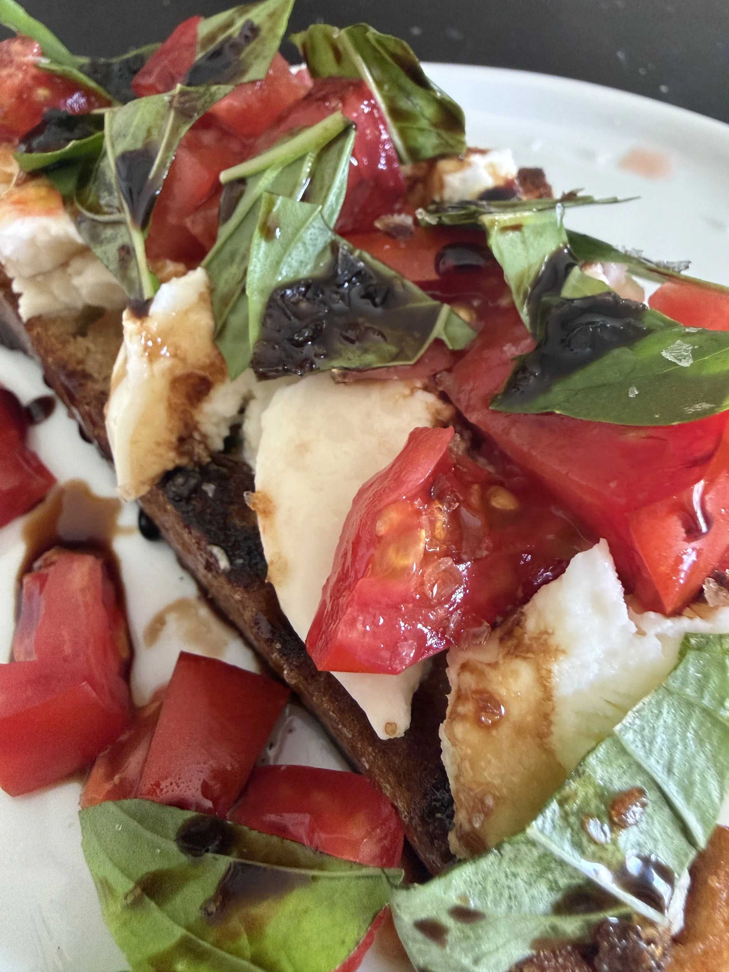 tomatoes and mozzarella with fresh basil on olive oil toast