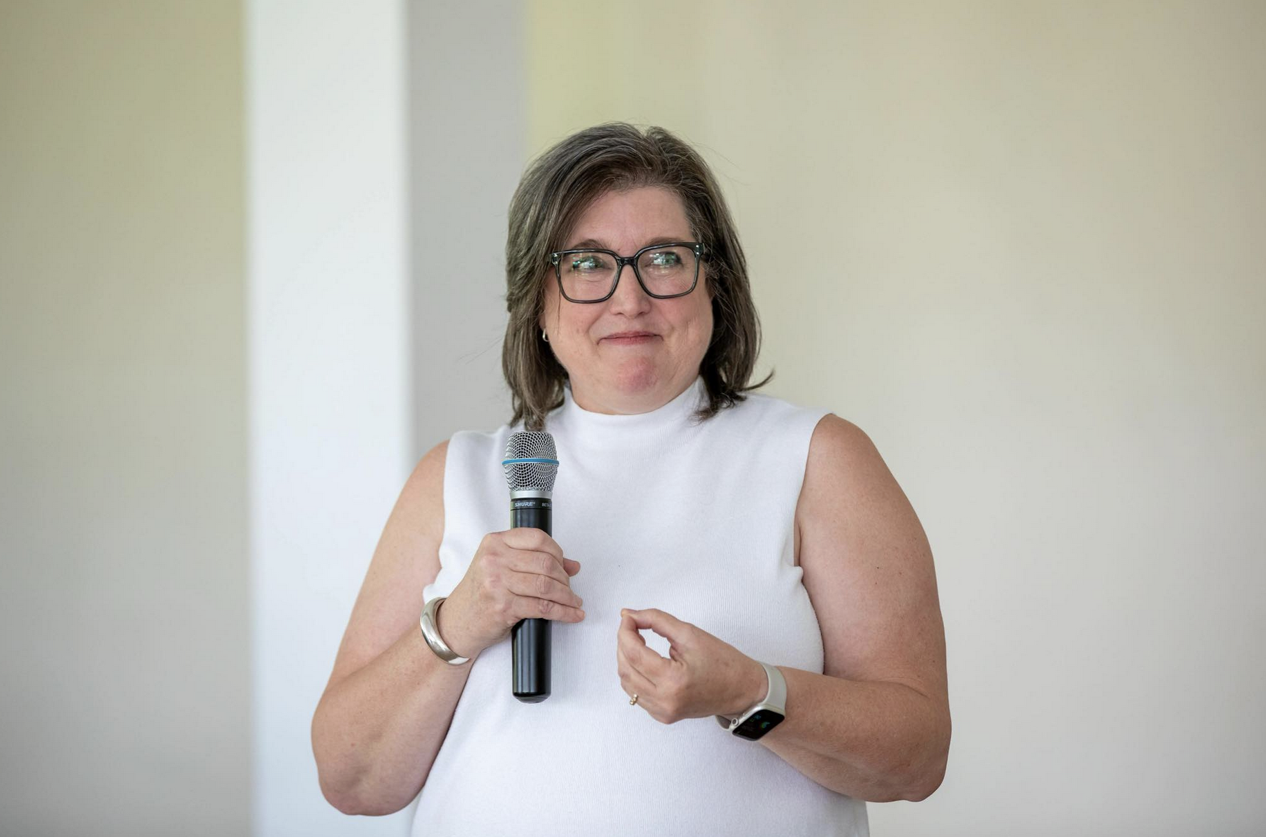 woman in white sweater holding microphone