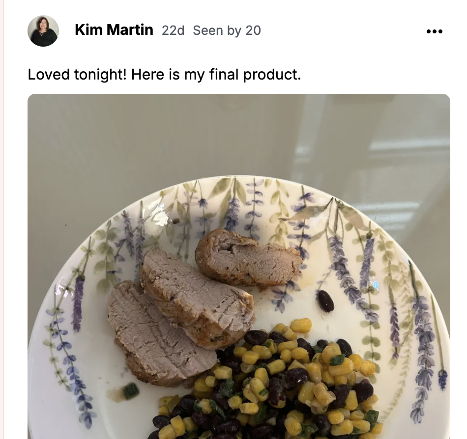 Sliced pork tenderloin with corn and black bean salad on a lavender-sprig plate.