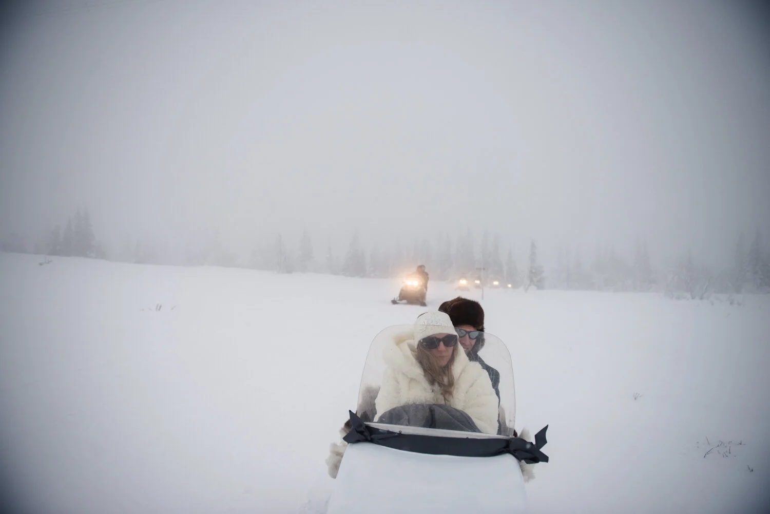 Brudpar åker skoter på väg till vigsel i snöstorm.