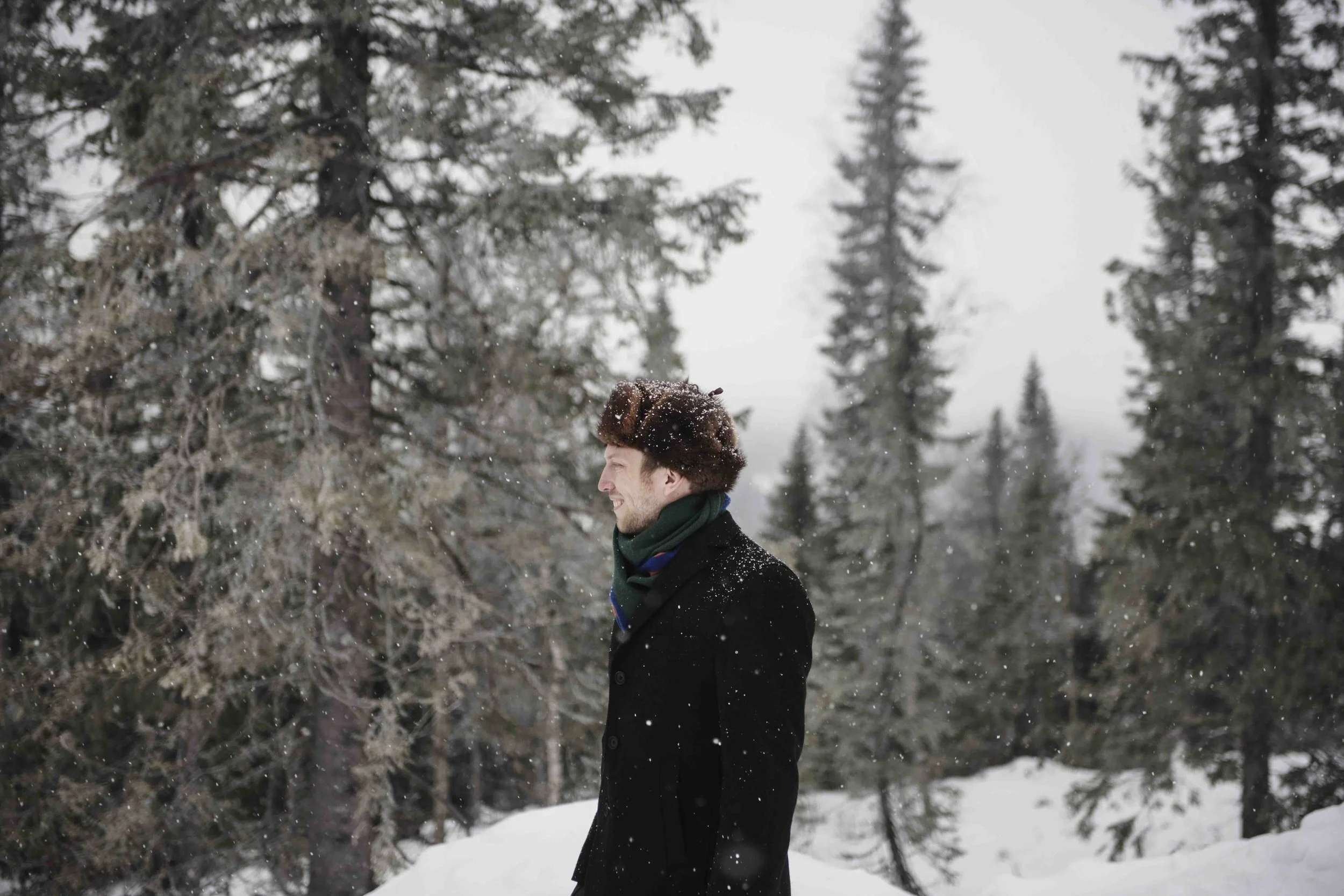 Brudgum fotad i fallande snö.