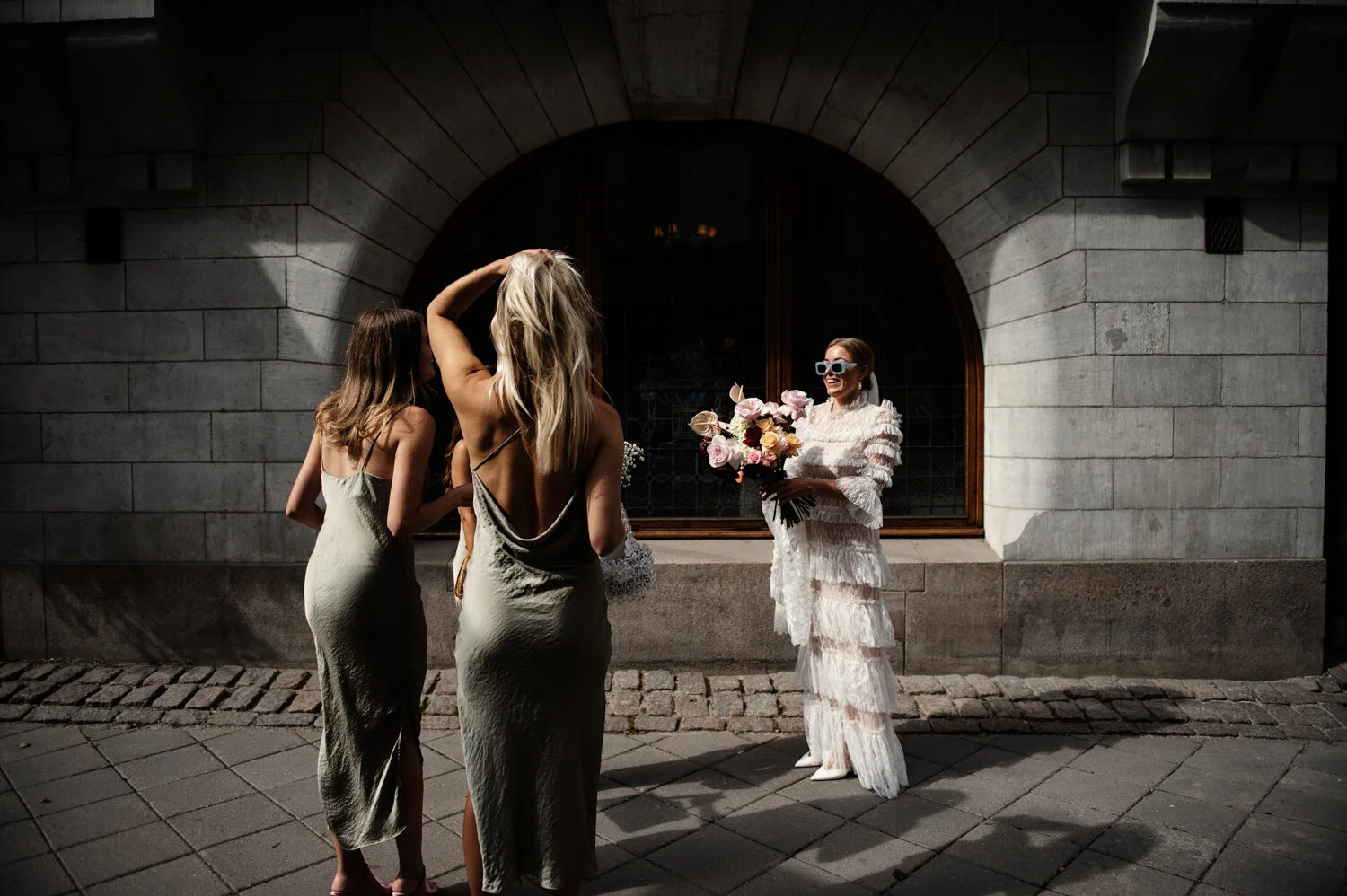 Brud med solglasögon och stor brudbukett.