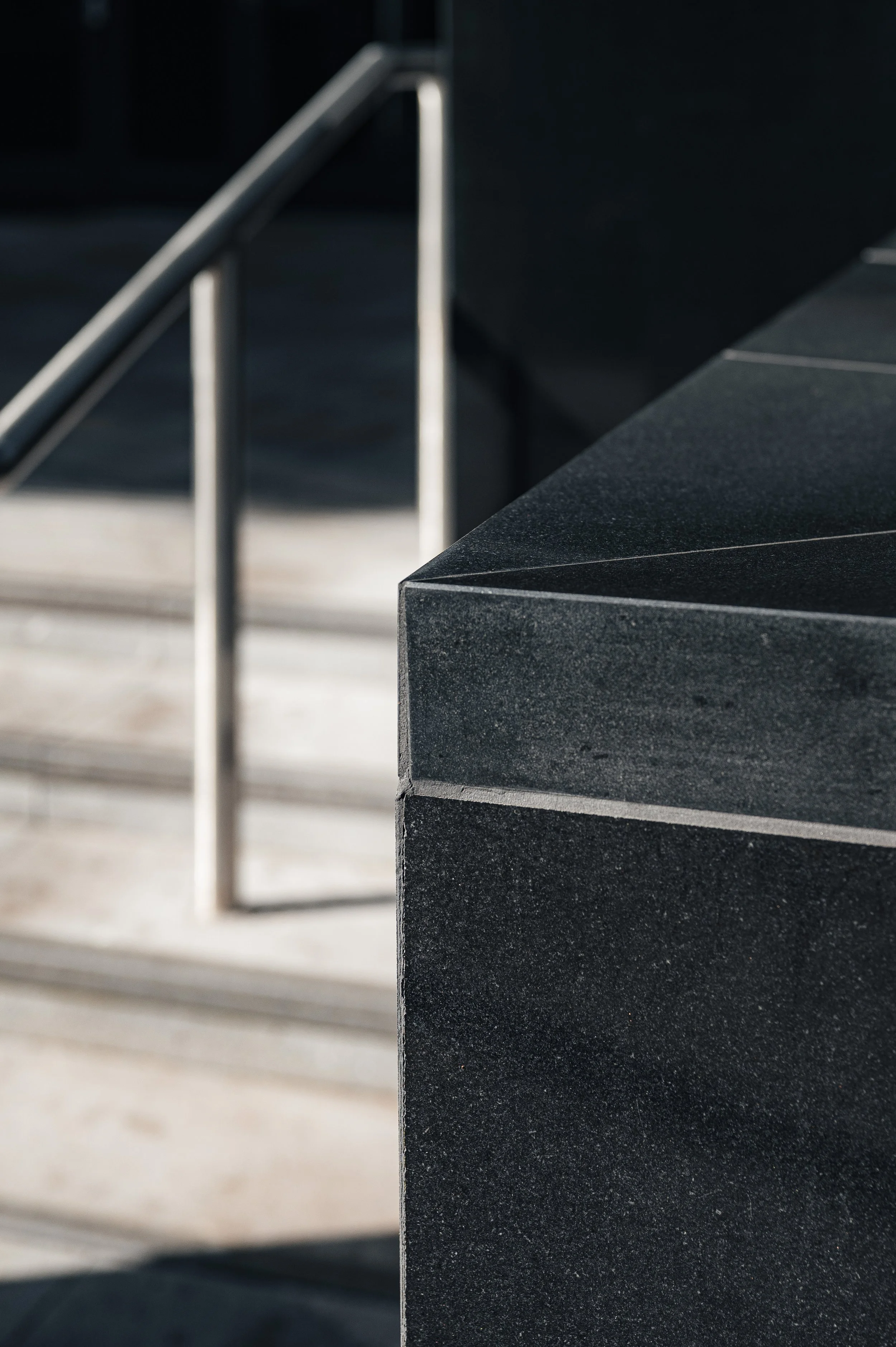Close-up of black stone façade detail at JP Morgan building highlighting texture and material finish.
