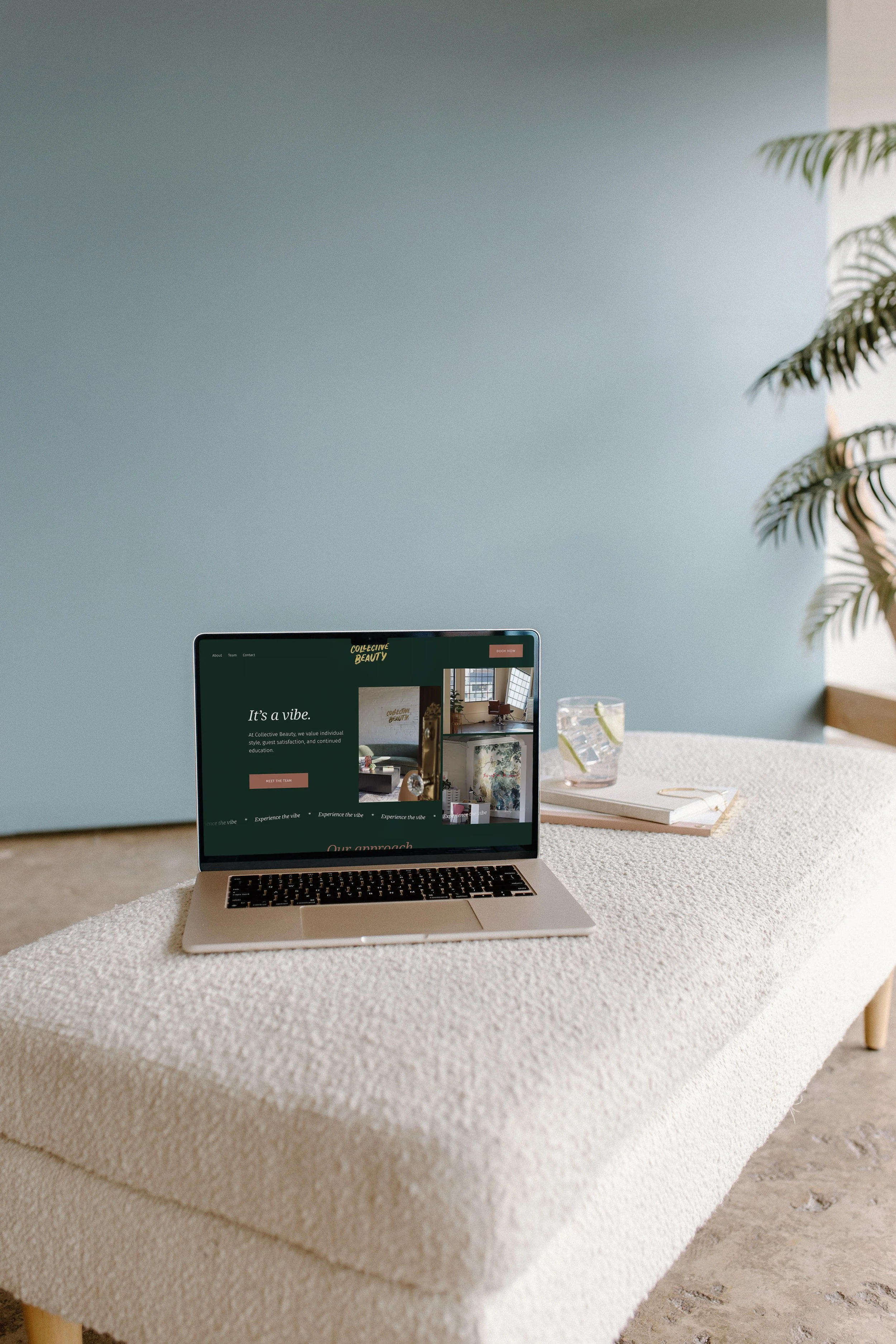 A MacBook laptop placed on a textured beige tablecloth, displaying a website titled 'Collective Beauty' with images and text about the brand.