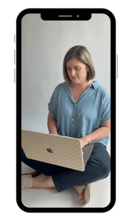 jackie burtch sitting cross-legged on the floor, using a laptop, inside a smartphone frame.