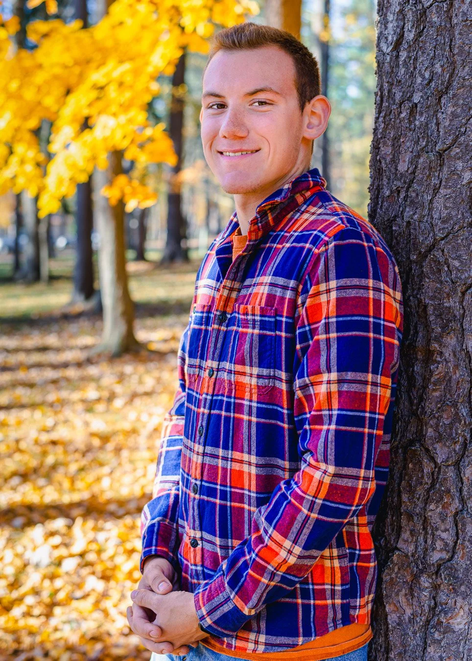 Alex leaning against tree