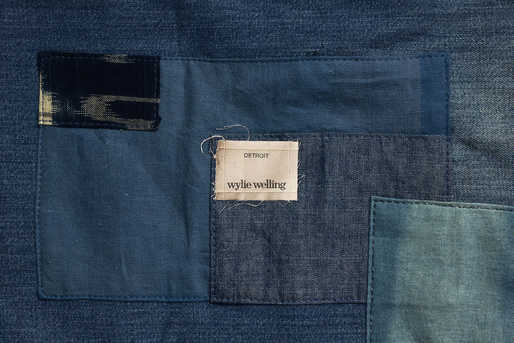 Wylie Welling "Detroit" woven label on a patchwork denim background. Creative brand identity and textile design by Scorpion Rose Studio and Lafayette American for heritage apparel.