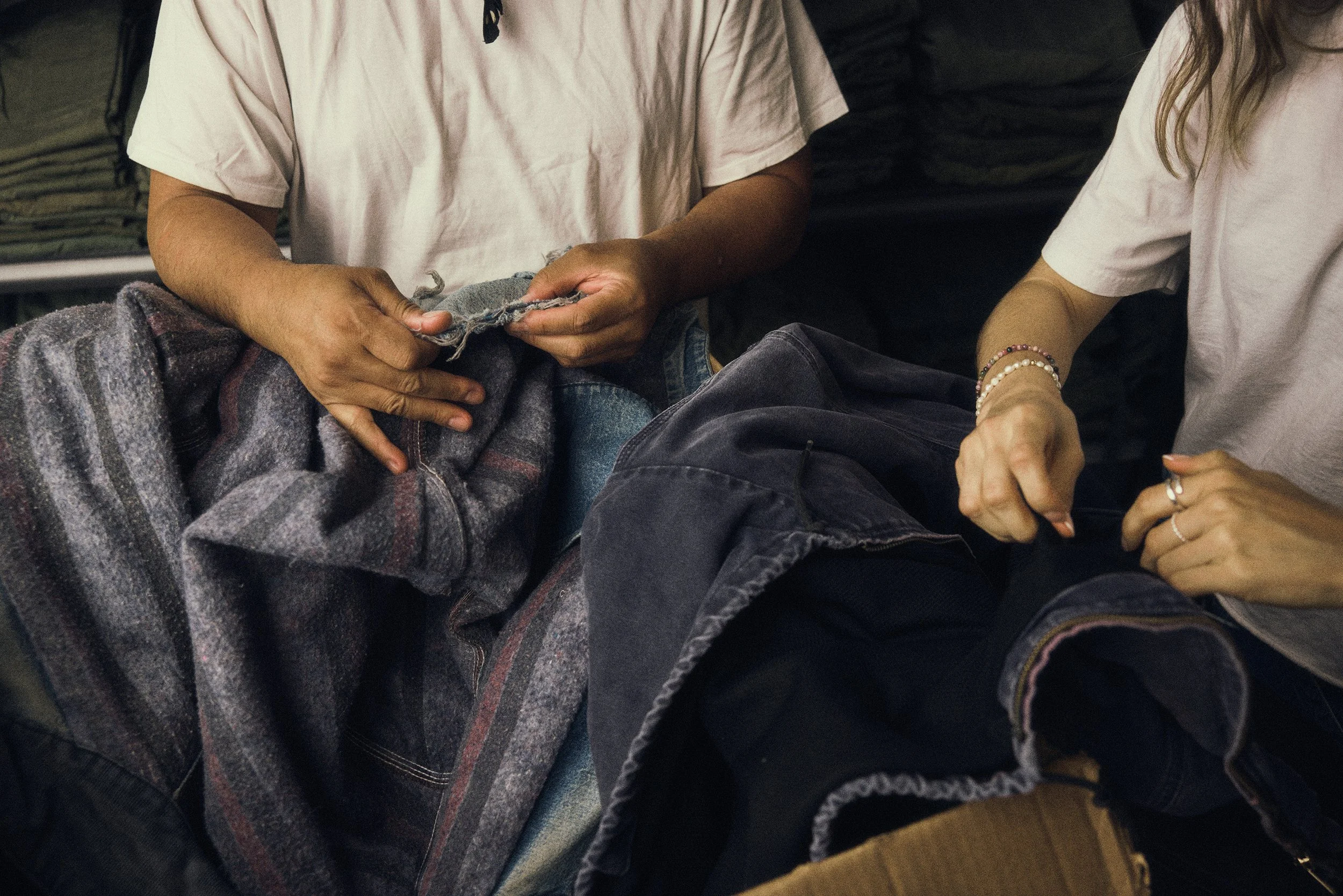 Artisans sorting through vintage textiles and heavy-duty outerwear. Behind-the-scenes creative process and brand curation by Scorpion Rose Studio and Lafayette American.