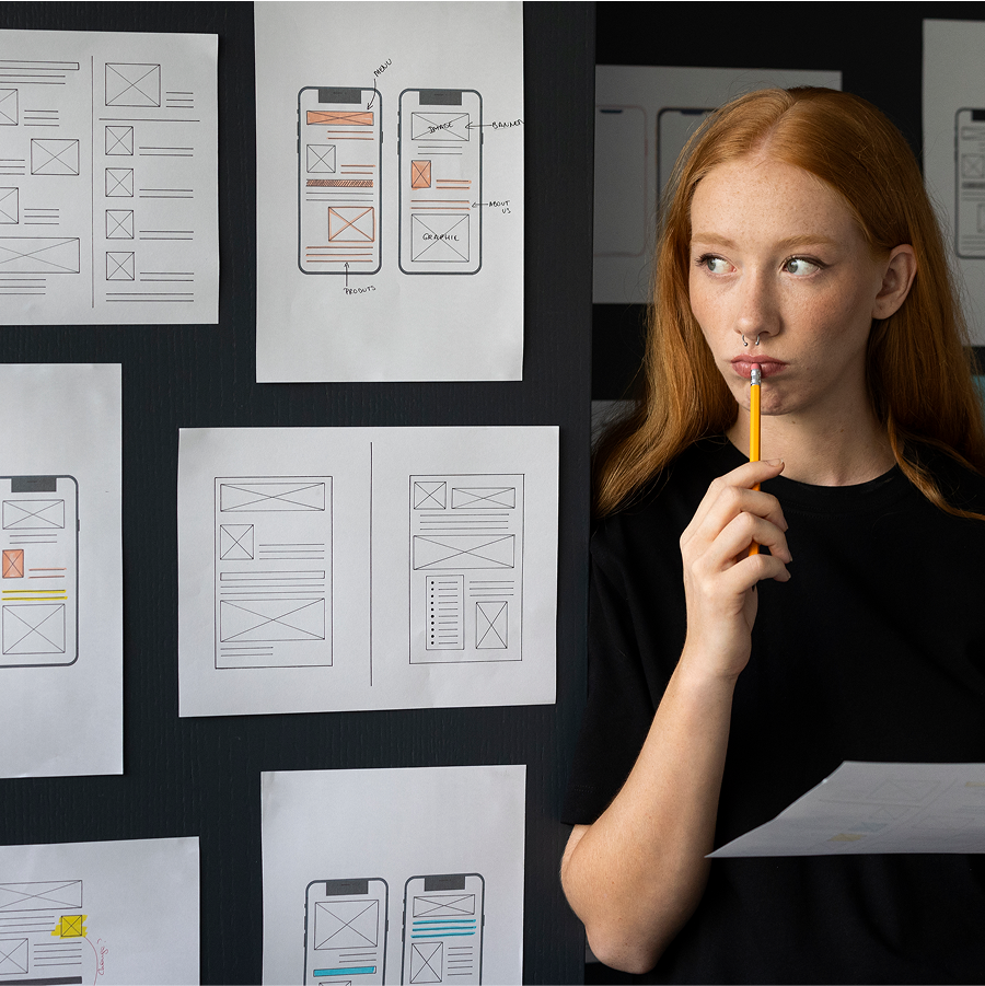 Mujer sosteniendo un lápiz y mirando un papel con un plan de marketing digital.