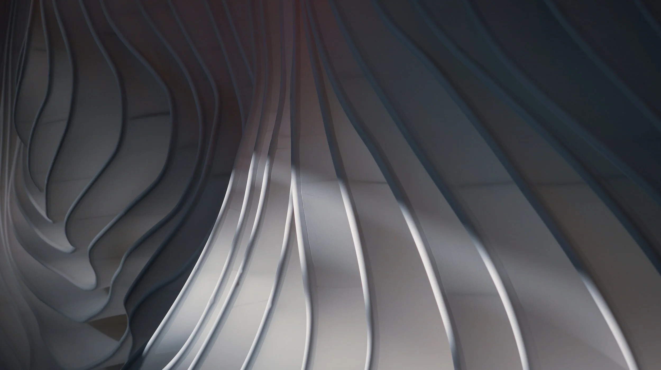 Abstract wavy architectural design with curved lines and shadows.