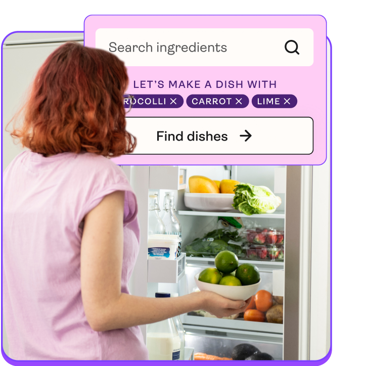 A young woman looking in the fridge holding a bowl of limes