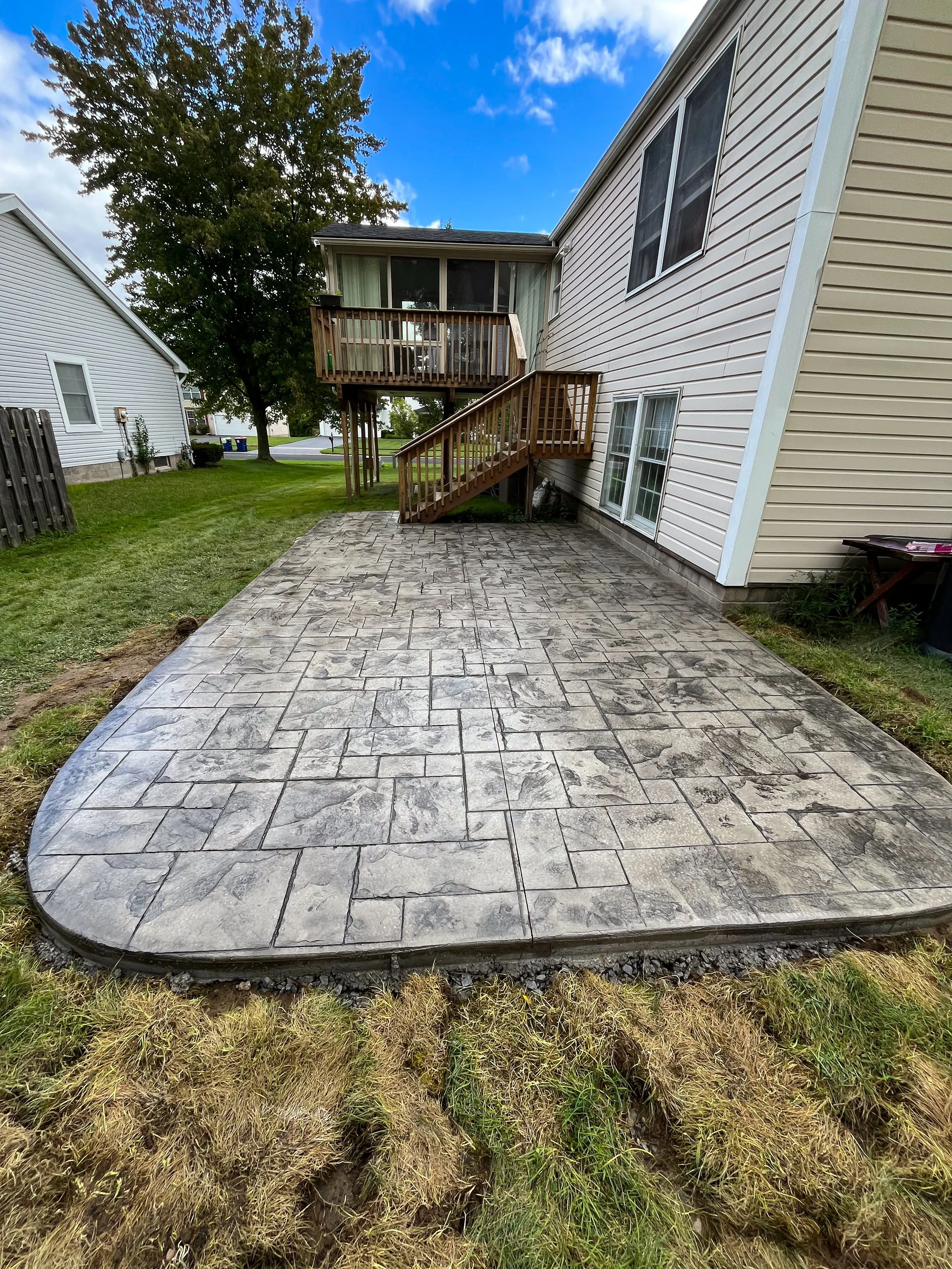 Grand slate stamped patio at the bottom of a deck