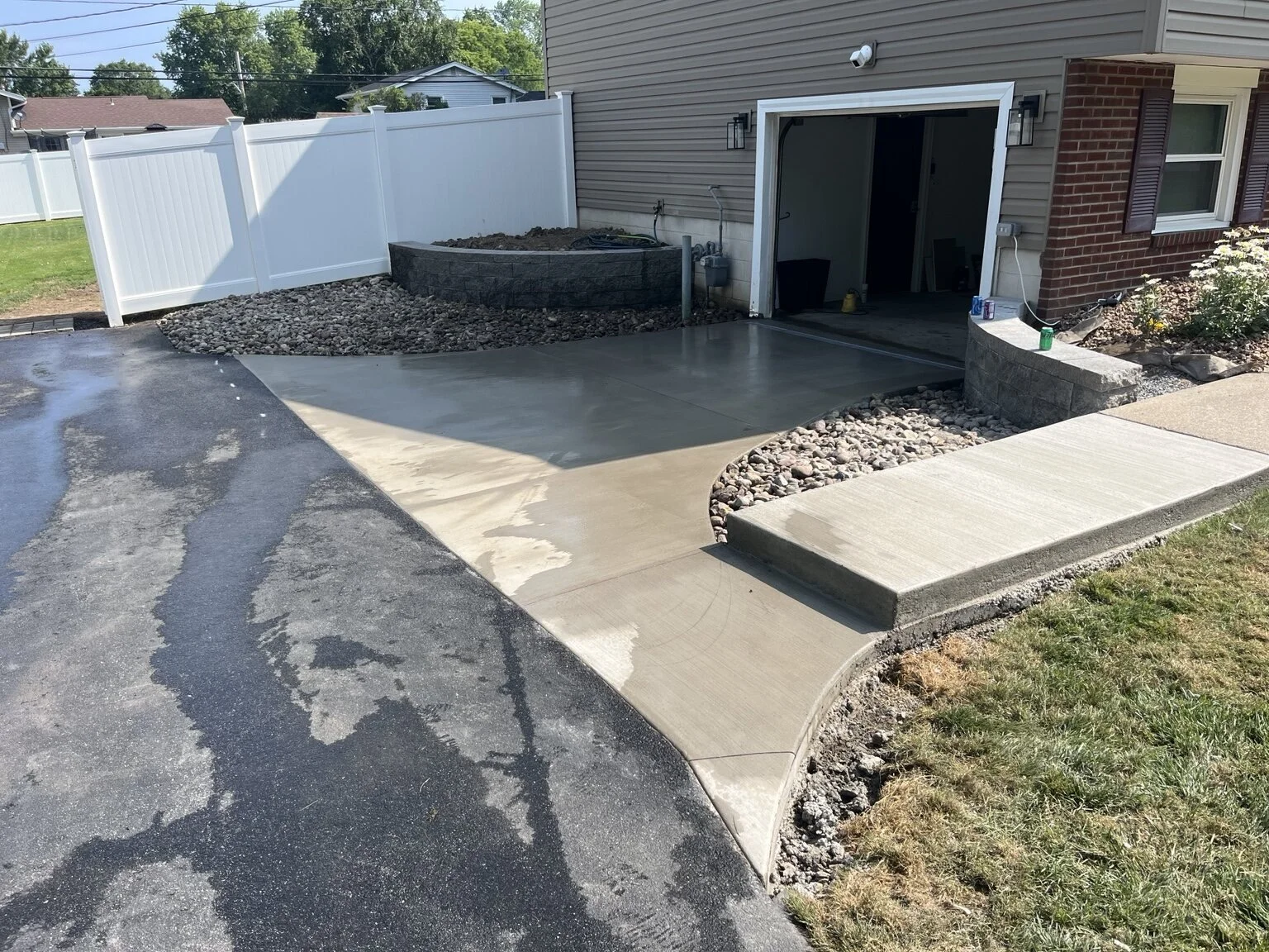 Concrete driveway drainage correction with a trench drain and dry well in Greece, NY.